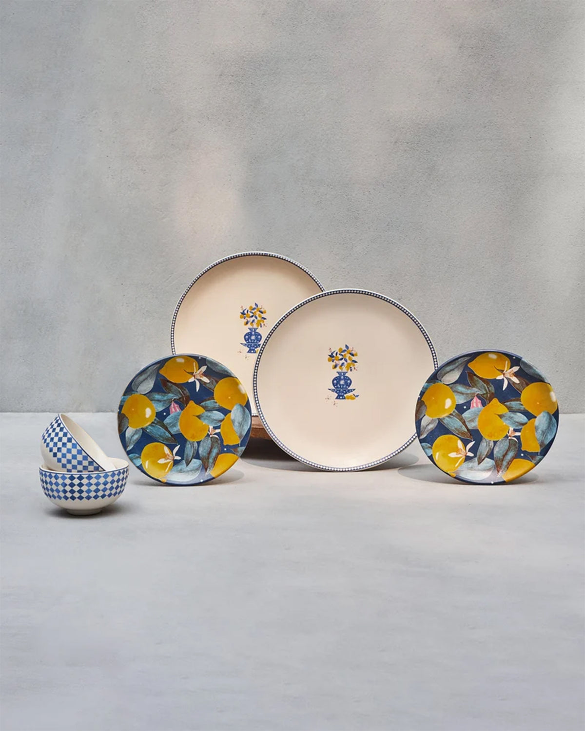Sahara dinner set with lemon-motif plates, navy lemon side plates, and blue checkered bowls.