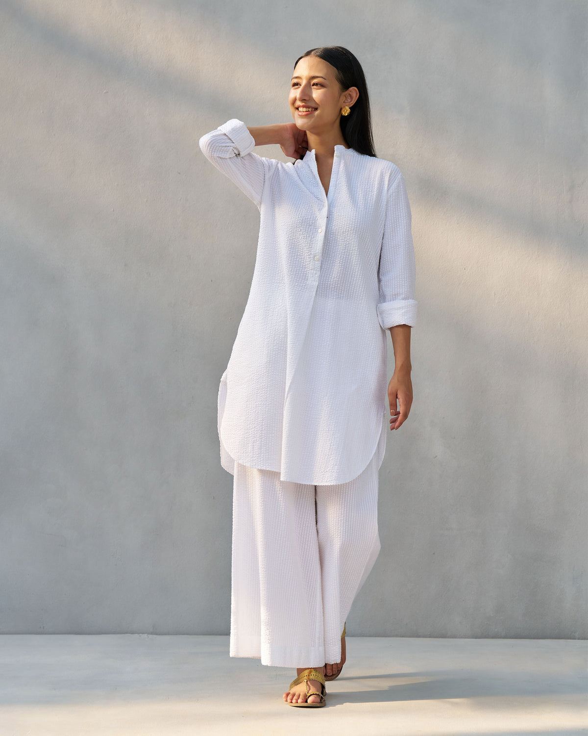 Person wearing white seersucker Basic Pyjamas in a matching button-down set.