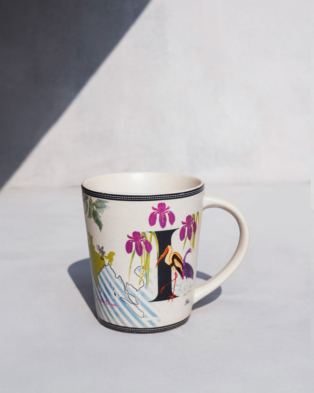 The Imli Mug with purple irises and a stork.