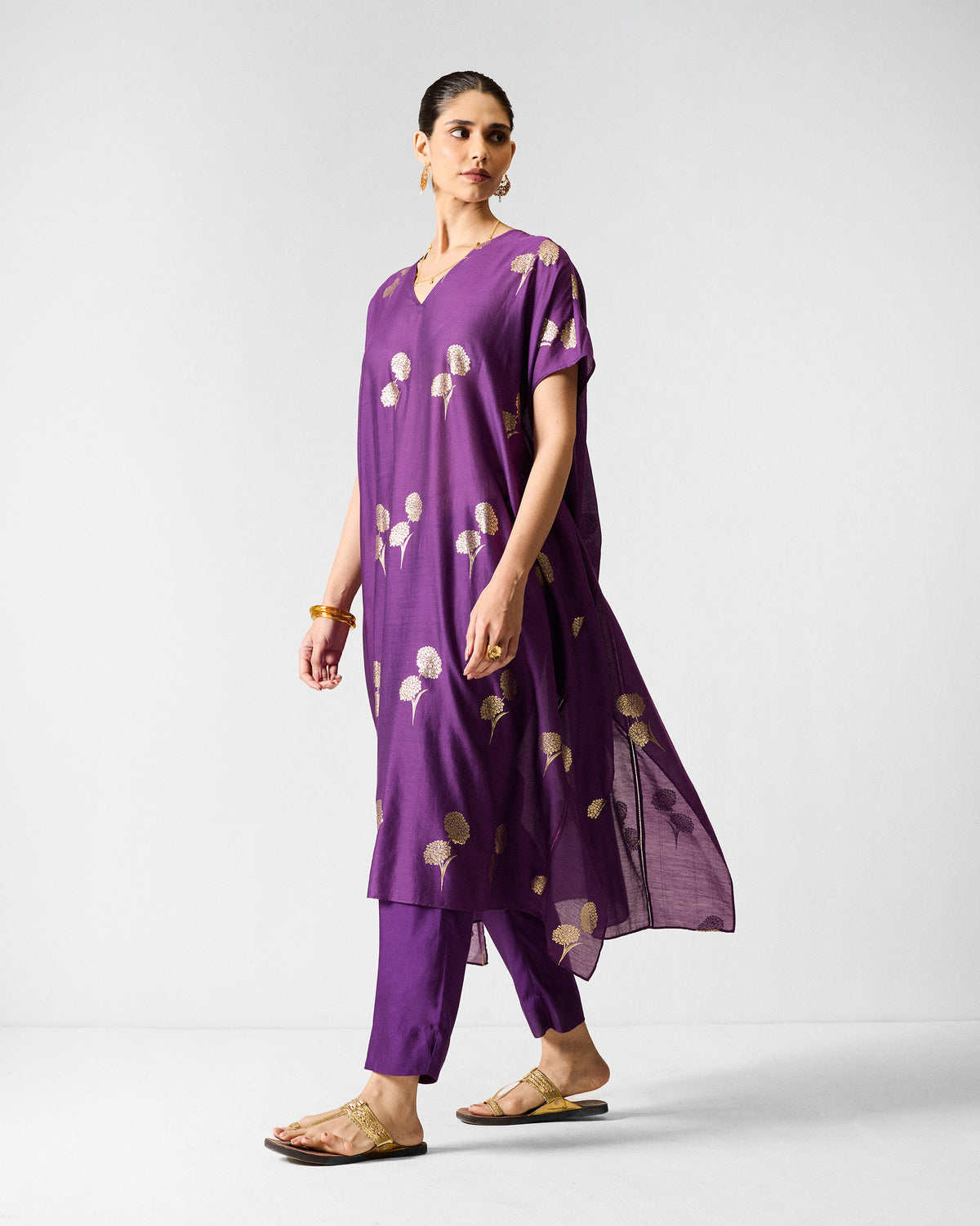 Person wearing a purple Diu Kurta with gold printed motifs.