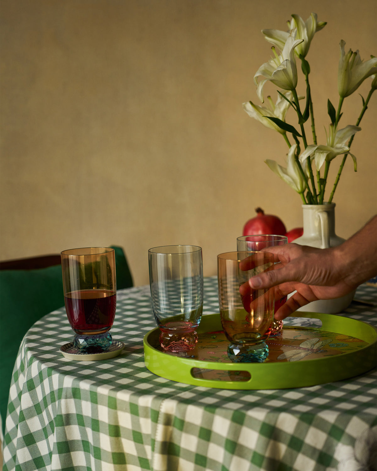 Reva sharbat glasses with faceted bases on a green serving tray.