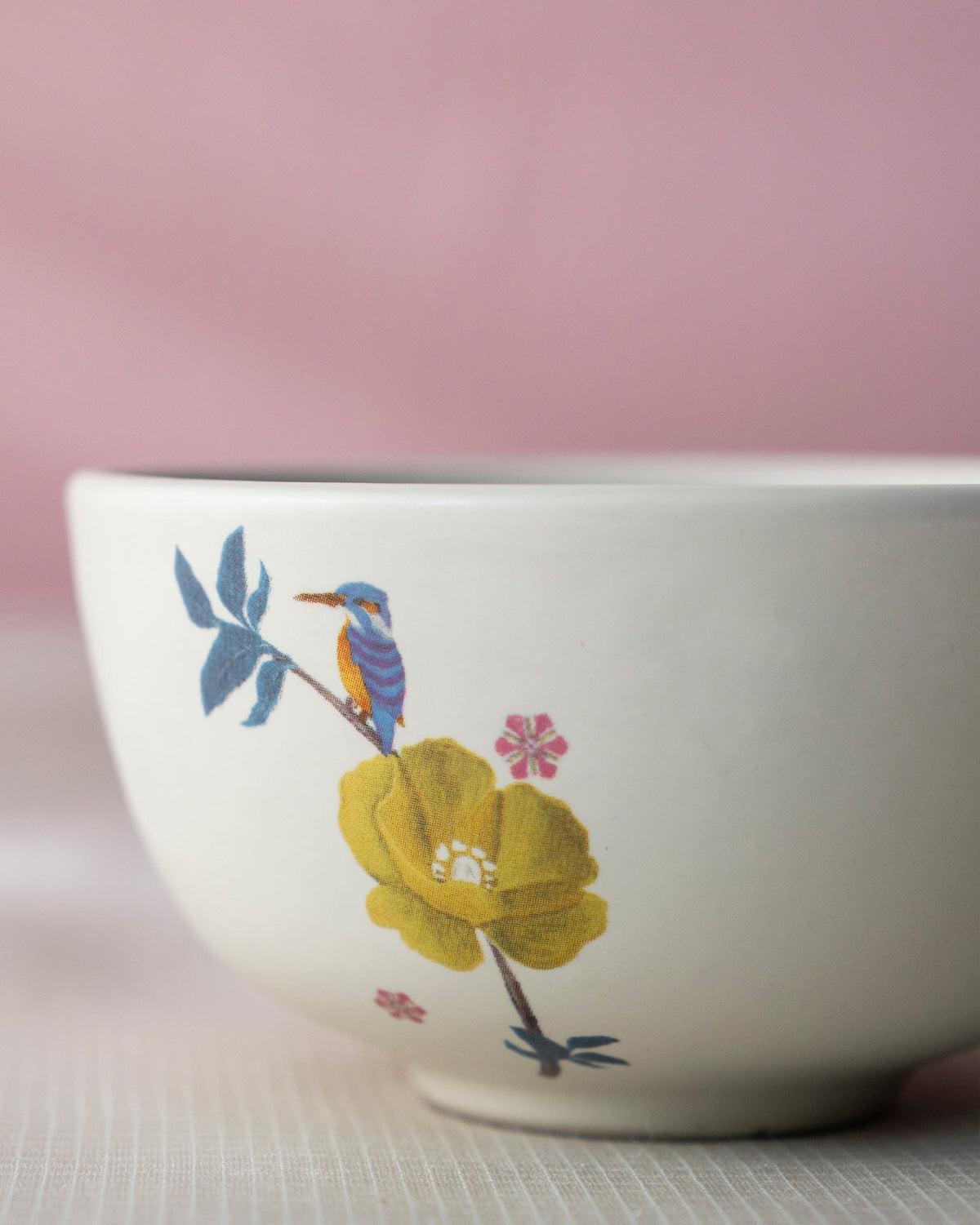 Myra katori with a kingfisher perched on a yellow flower.