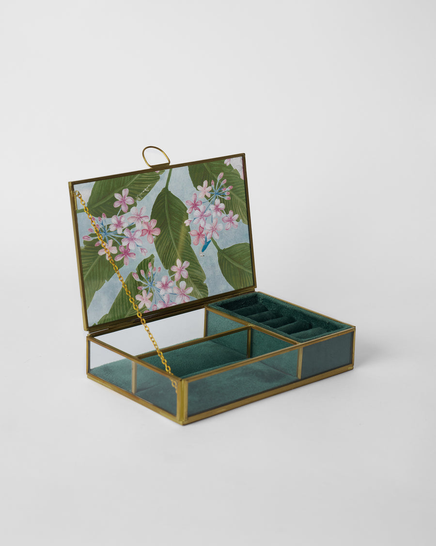 The open Madhumalti box, a floral glass lid over teal velvet