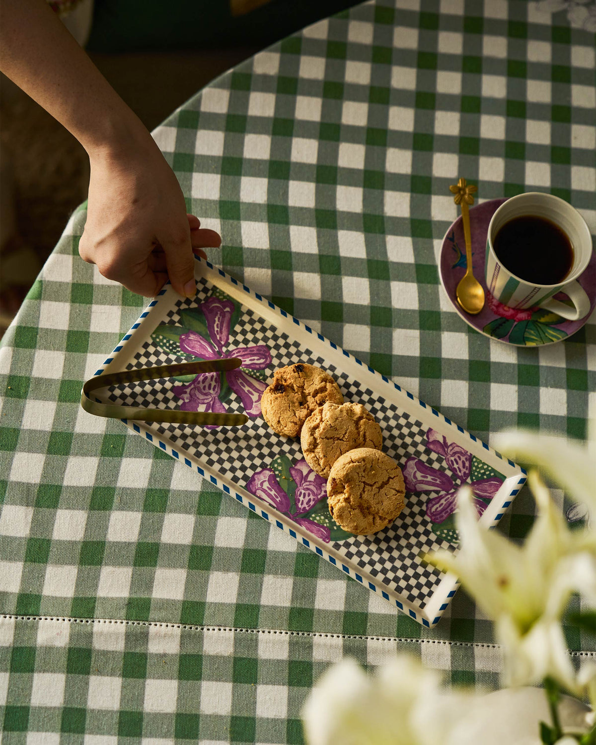 Buransh Cookie Tray holding cookies and gold tongs on a table with coffee.