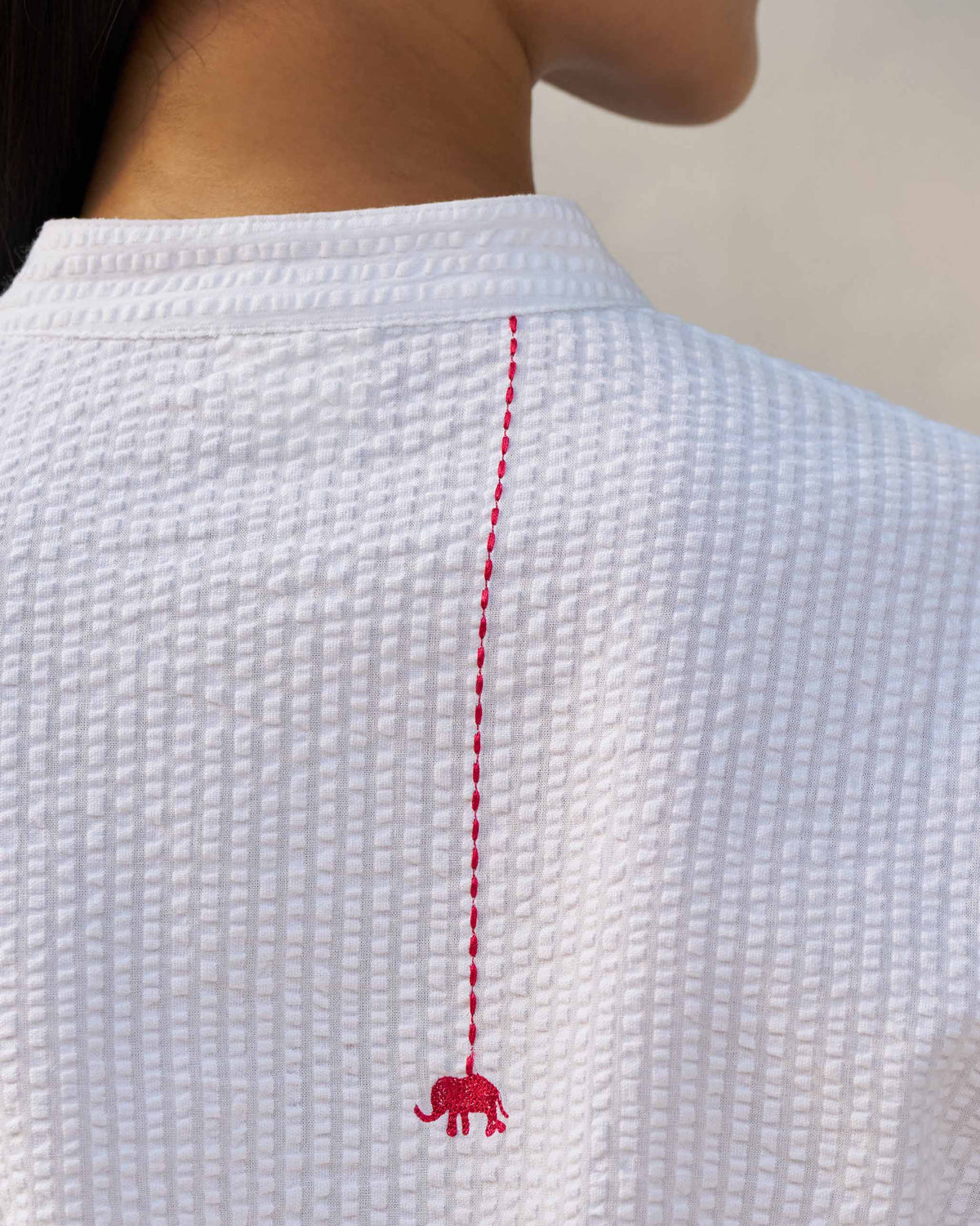 Close-up of a red embroidered elephant on the back of a white Ice Set kurta.