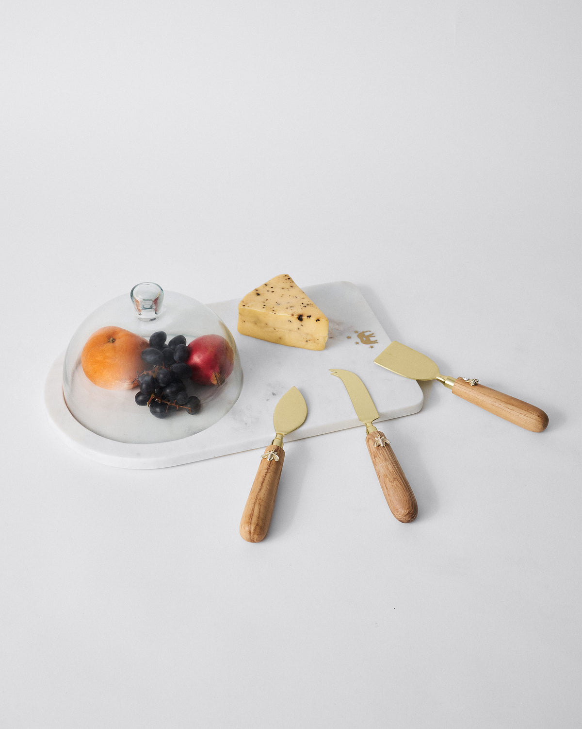 Fromage set with a glass dome cover and three knives with wooden handles.