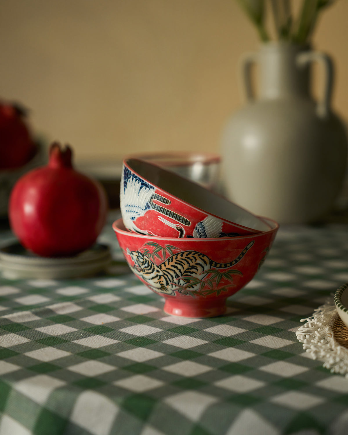Stacked red Crane and Tiger bowls showing tiger and crane motifs.