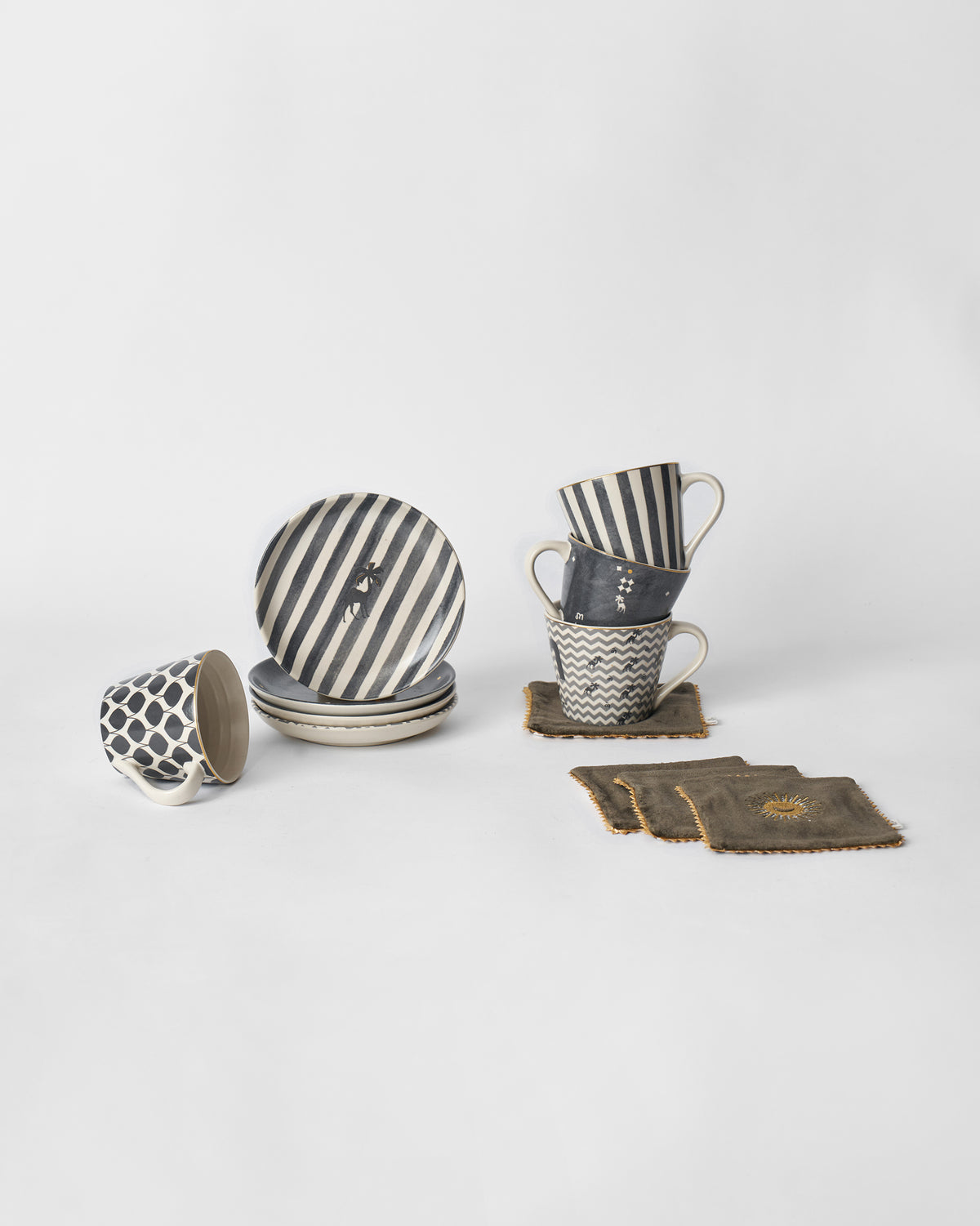 Twilight gift set mugs, deer-motif plates and olive coasters laid out together.