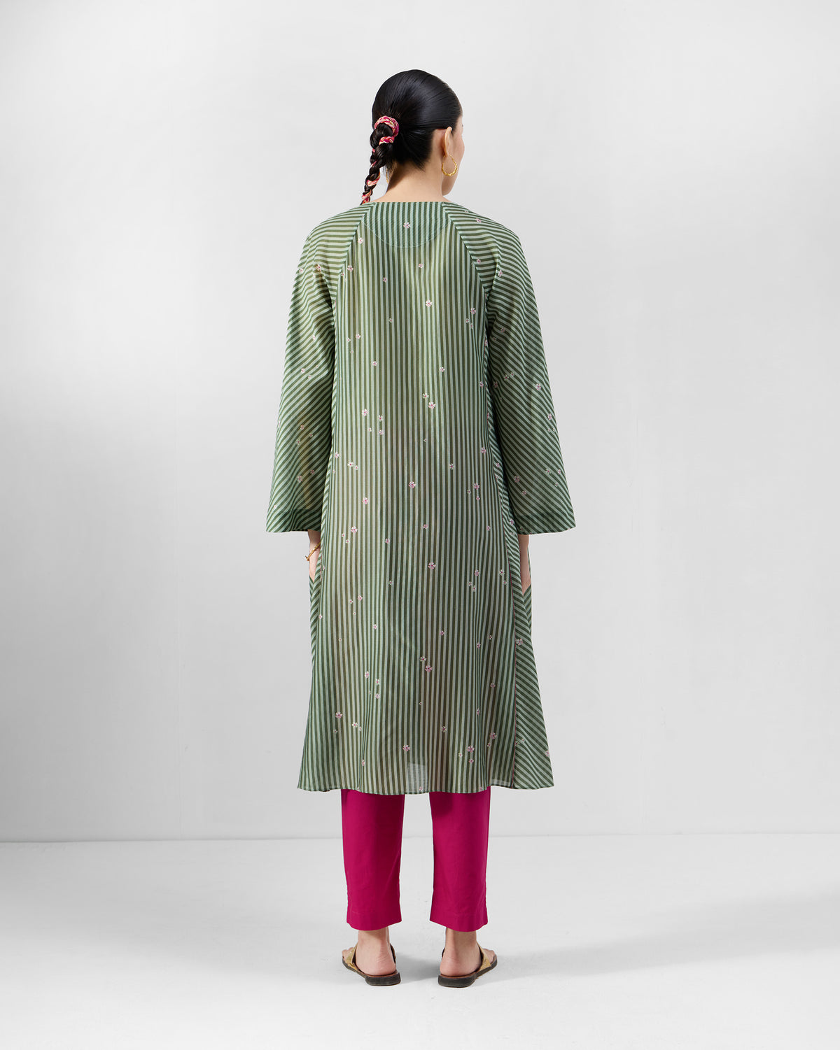 Back of a green and soft pink striped A-line Kutch kurta worn by a person.