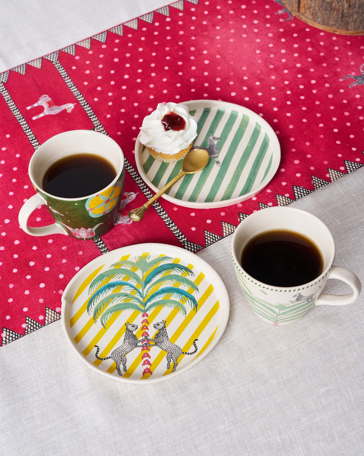 Teatime set mugs beside a leopard and palm plate.