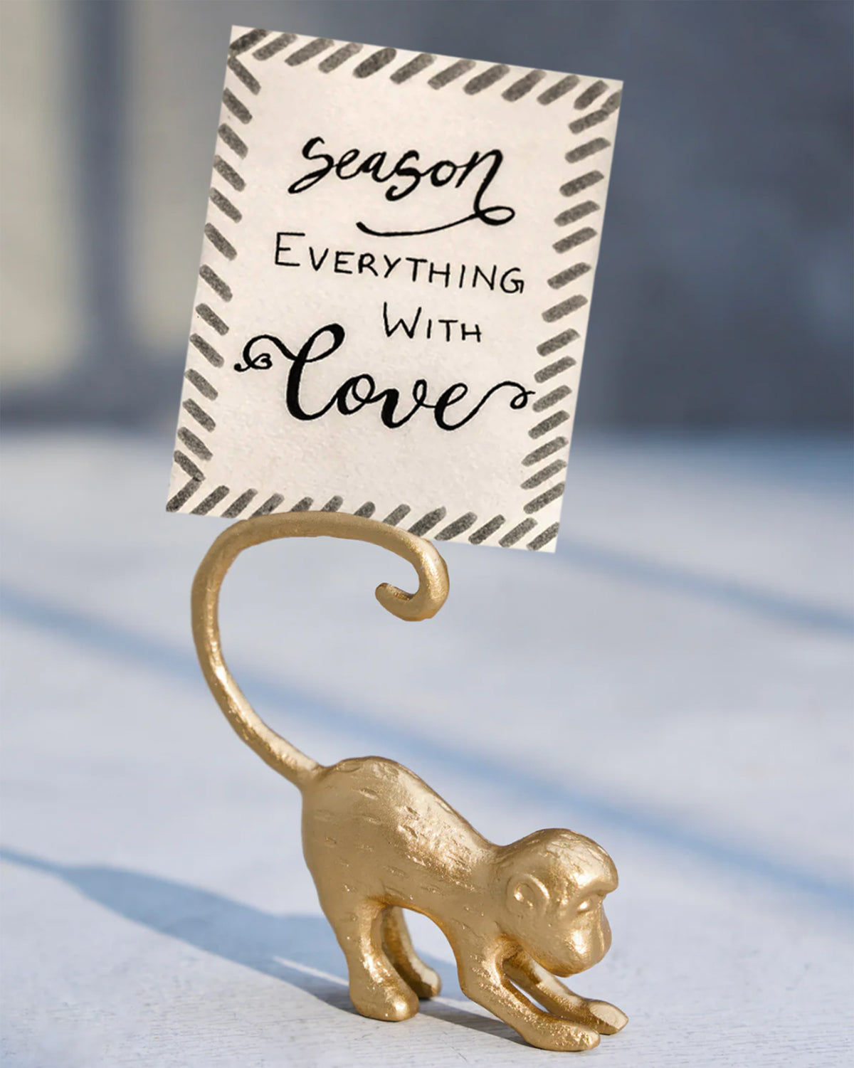 Gold monkey menu card holder holding a printed card.