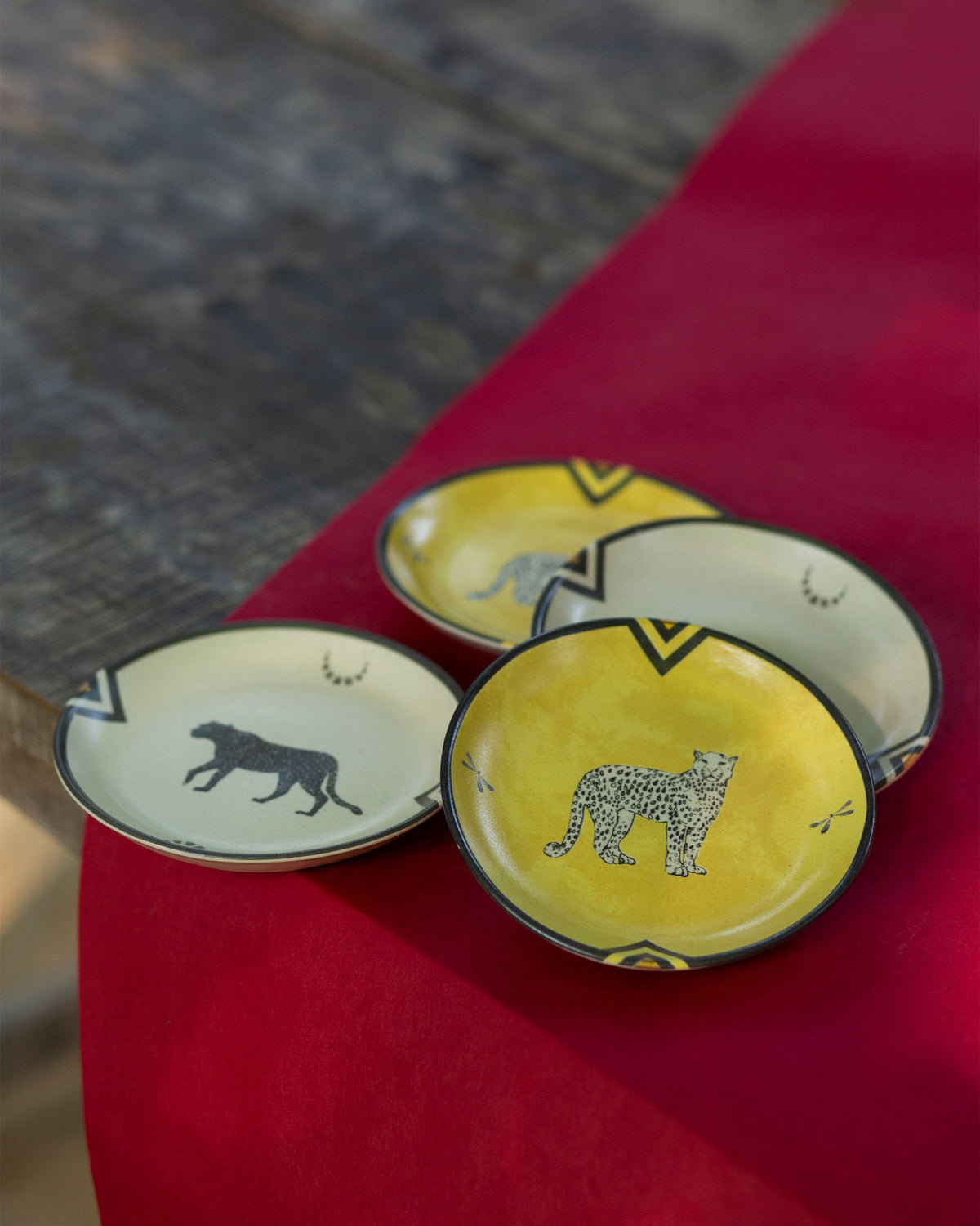 Chand cheetah tea plates in yellow and cream with leopard motifs.