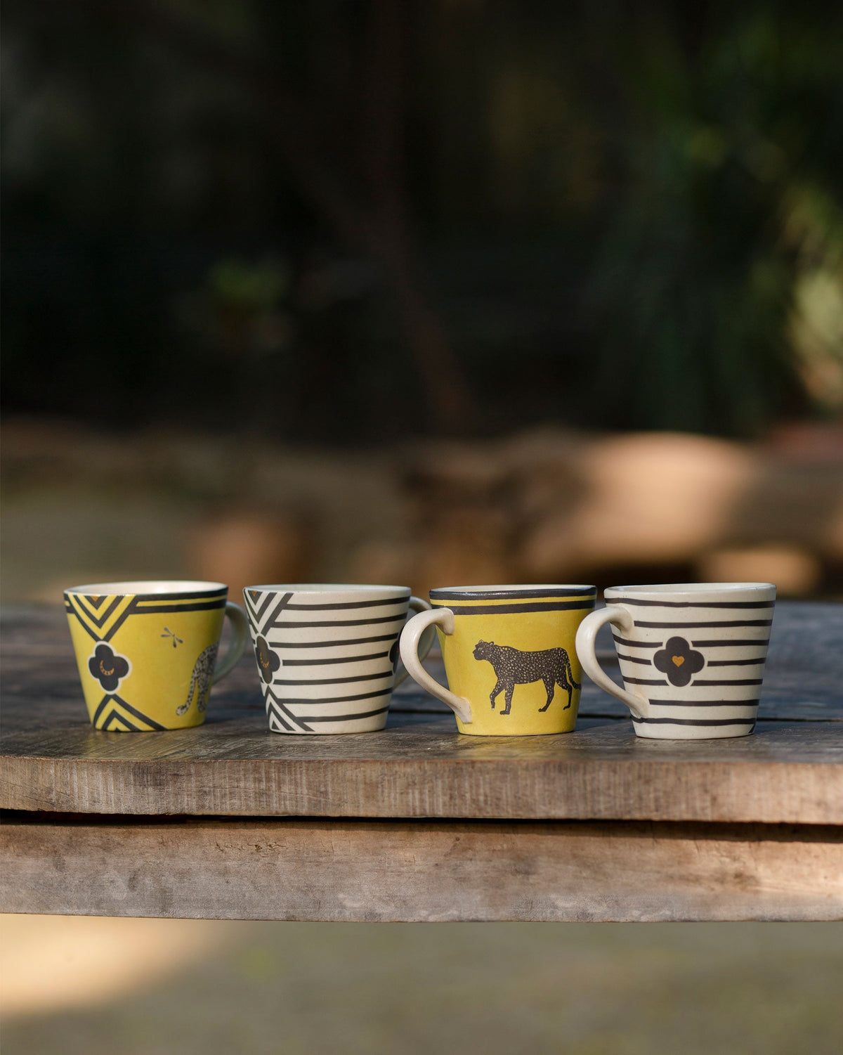 Four Chand espresso mugs in yellow leopard and black stripe designs.