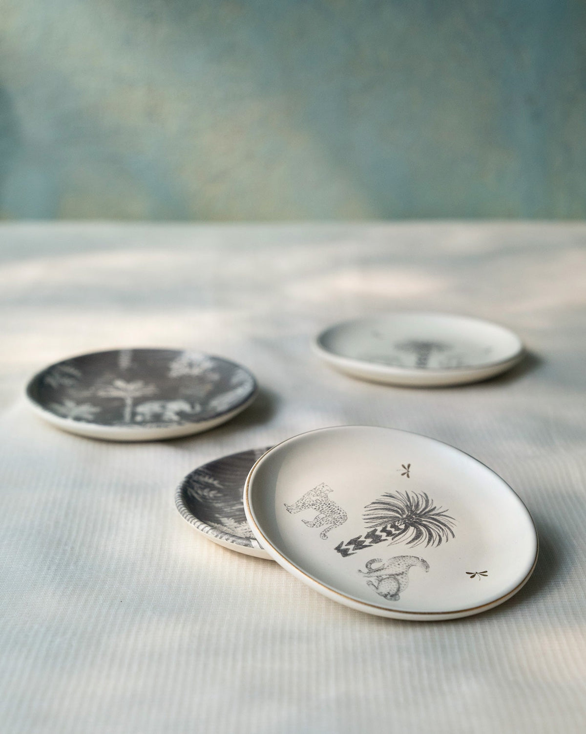 Stacked Periyar tea plates showing palm and elephant motifs.