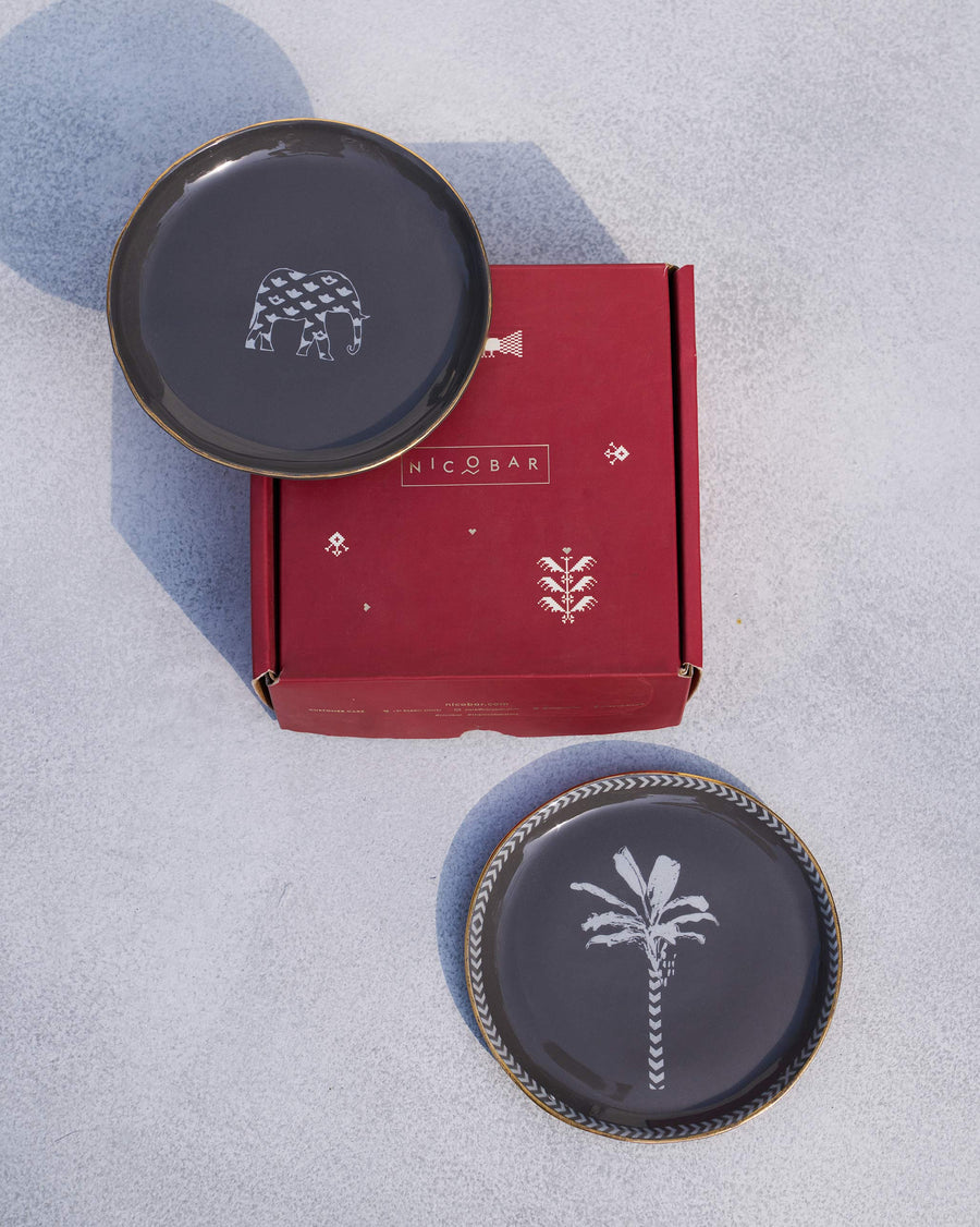 The charcoal Coastal Tea Plates with a red Nicobar gift box.