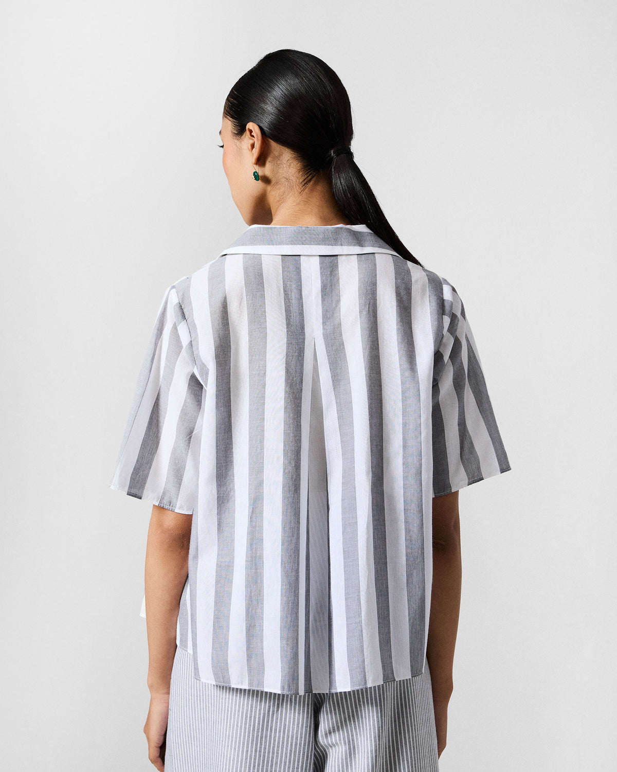 Back of a grey and white striped Rann shirt with a deep box pleat.