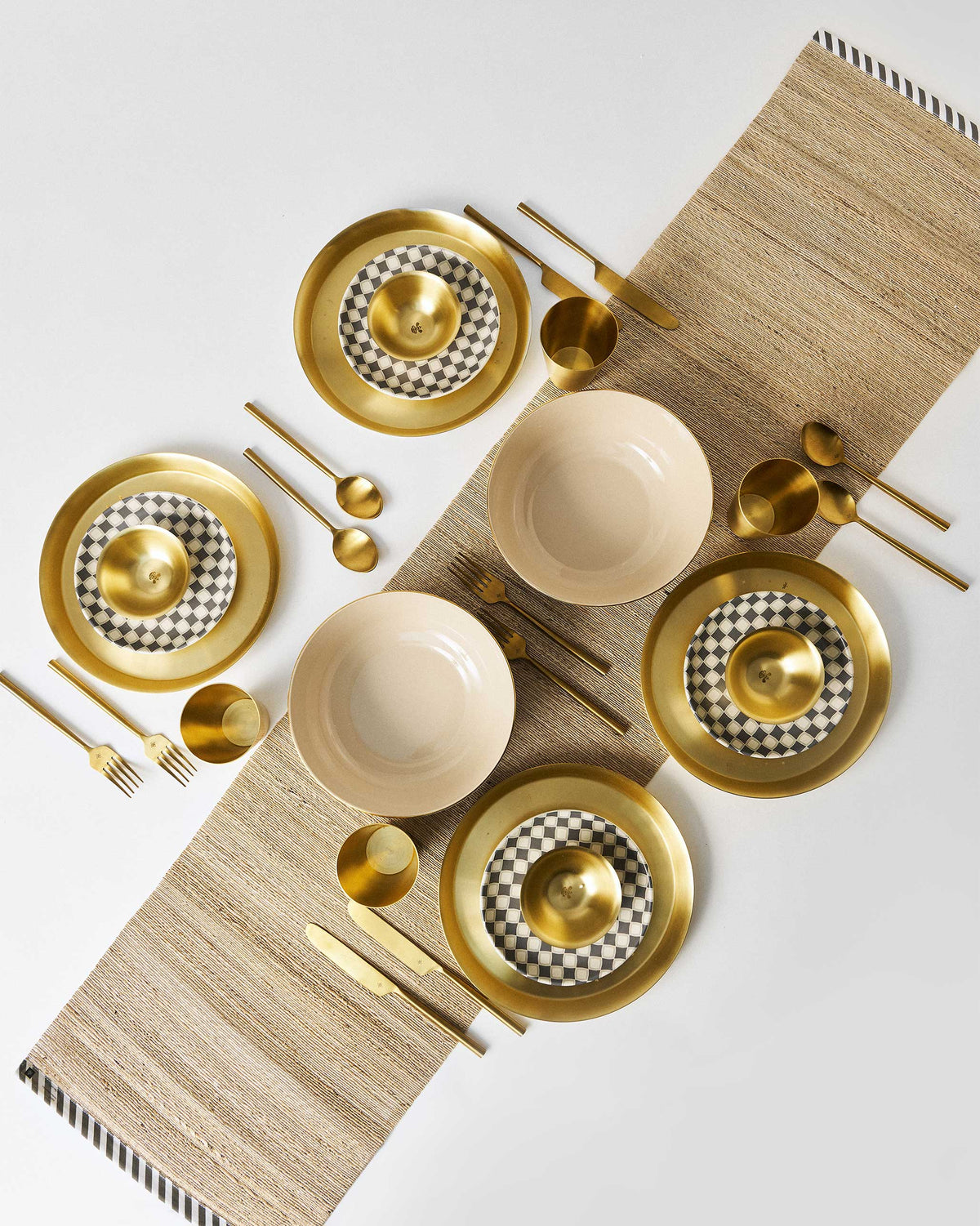 Overhead Brass Fez Dinner Set place settings on a woven runner.