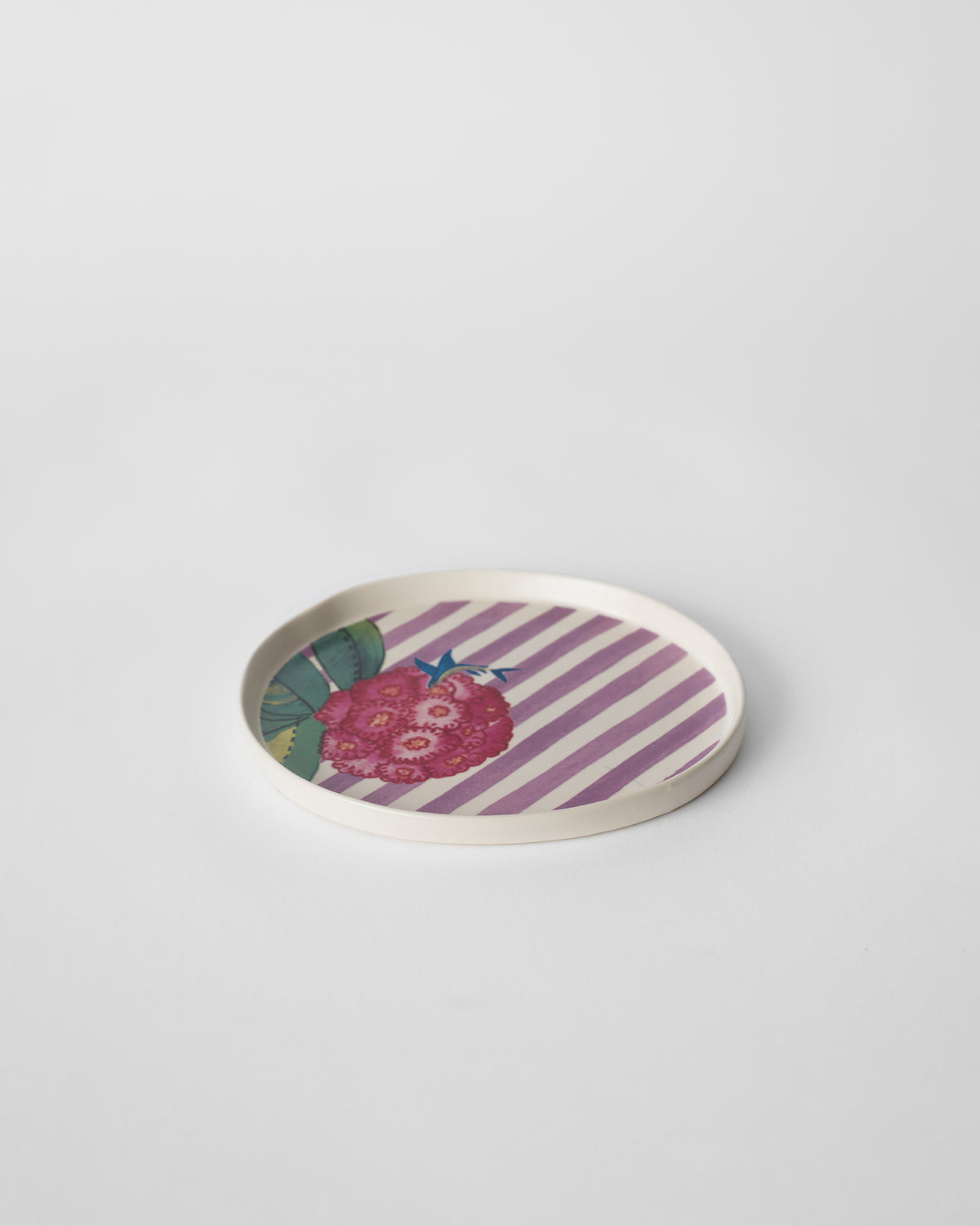 Three-quarter view of a Buransh dessert plate with pink blooms and stripes.