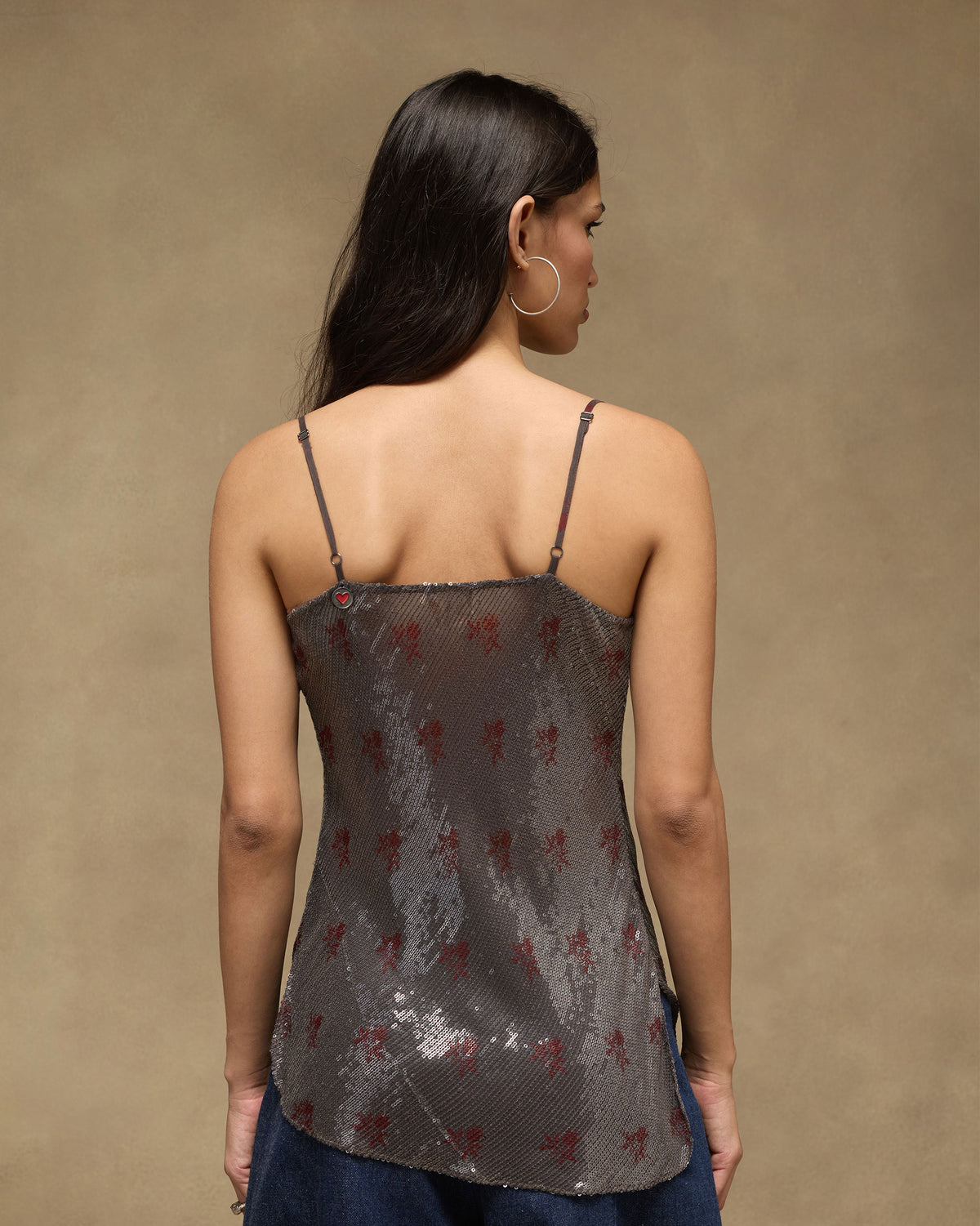 Back of a charcoal Flit top with a red heart at the strap.
