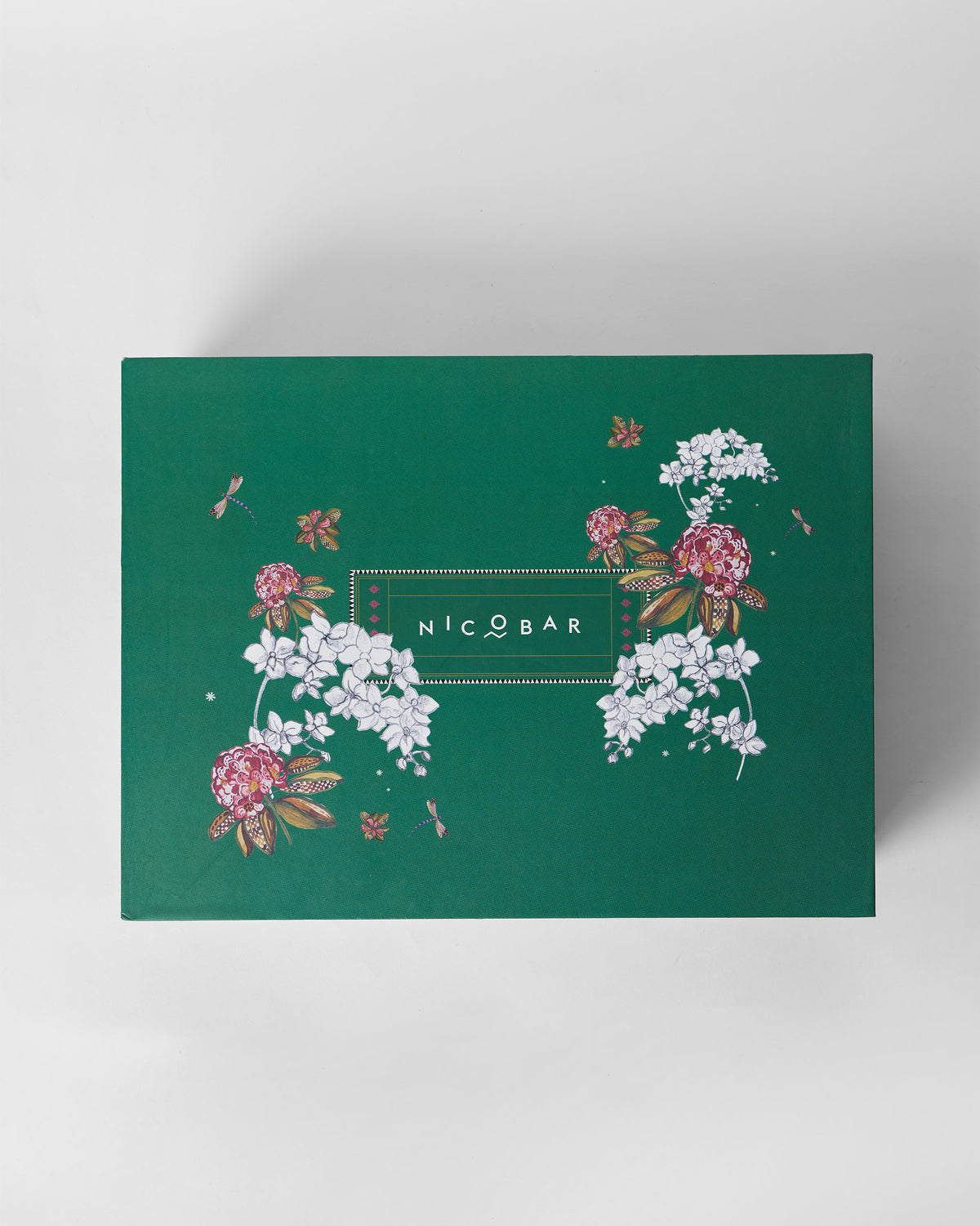 Hornbill gift set box lid with pink blossoms, dragonflies, and a Nicobar logo.