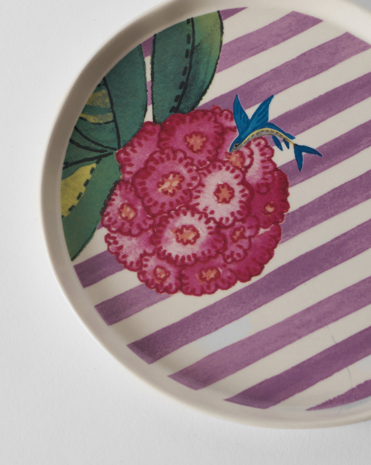 Close-up of Buransh dessert plate floral cluster on lavender stripes.