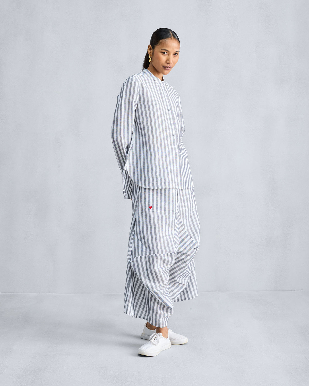 Side view of the Mandarin Collar shirt worn over striped wide trousers.