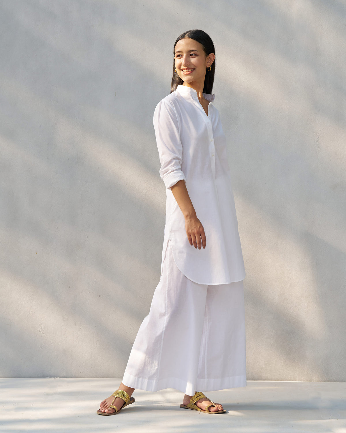 Side view of a white Moon set with a curved high-low tunic hem.