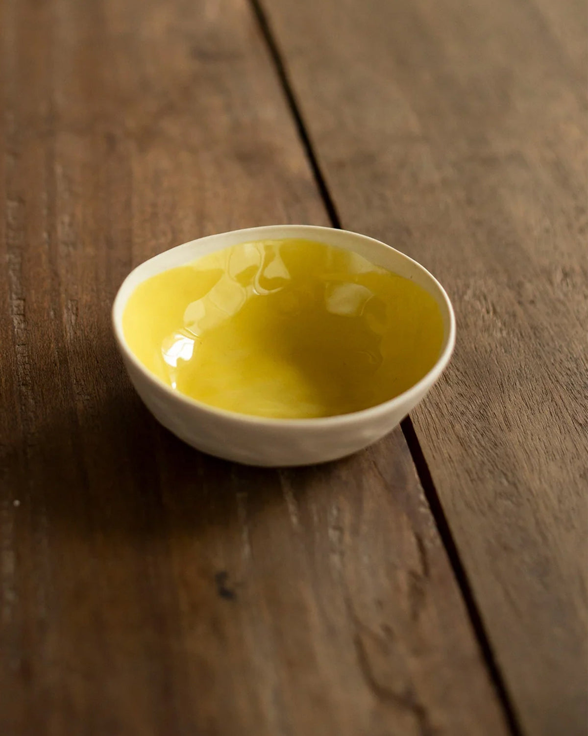 Close-up of a Mandovi bowl with a glossy lemon-yellow interior.