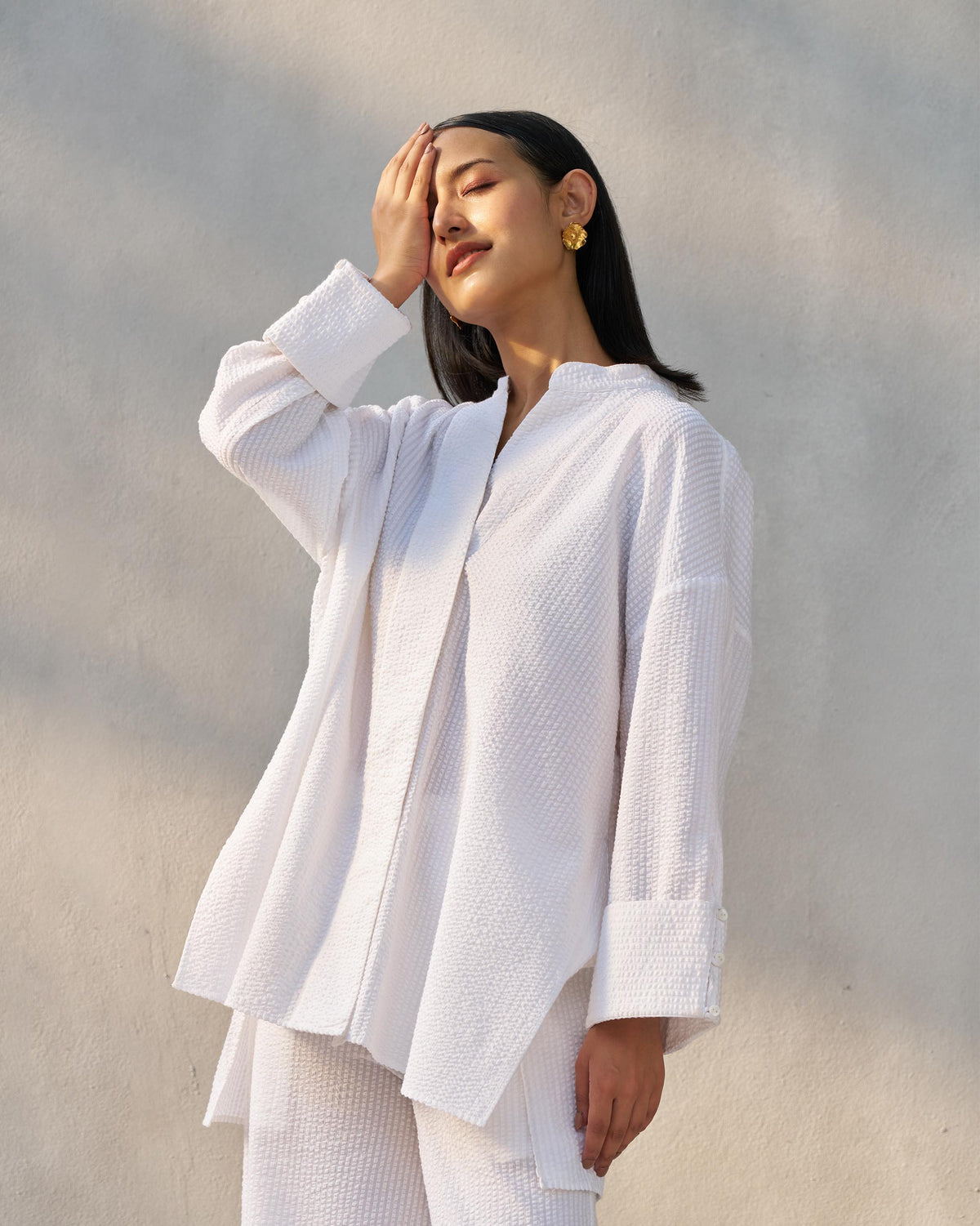 Person wearing a white seersucker Cirrus Set showing the high-low shirt hem.