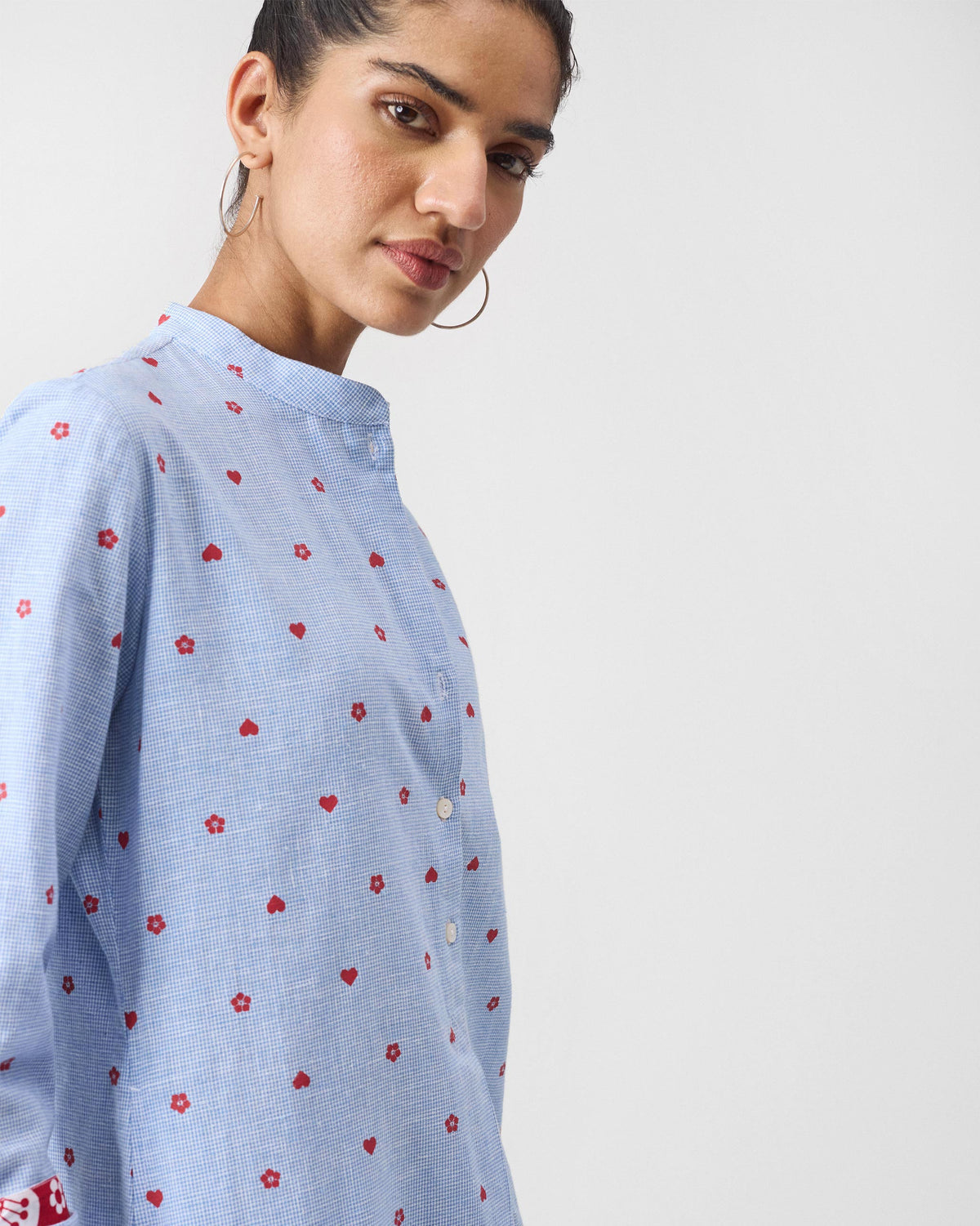 Close-up of a light blue Sakura set kurta with red heart and flower print.