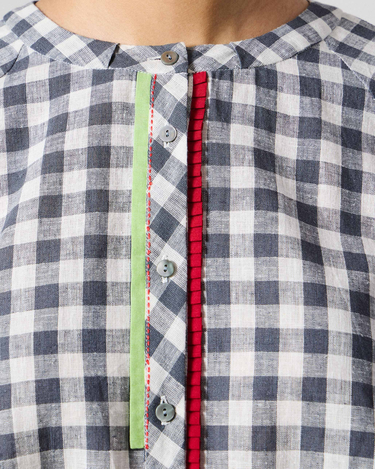 Close-up of lime and red kantha trim on a charcoal check Zil placket.
