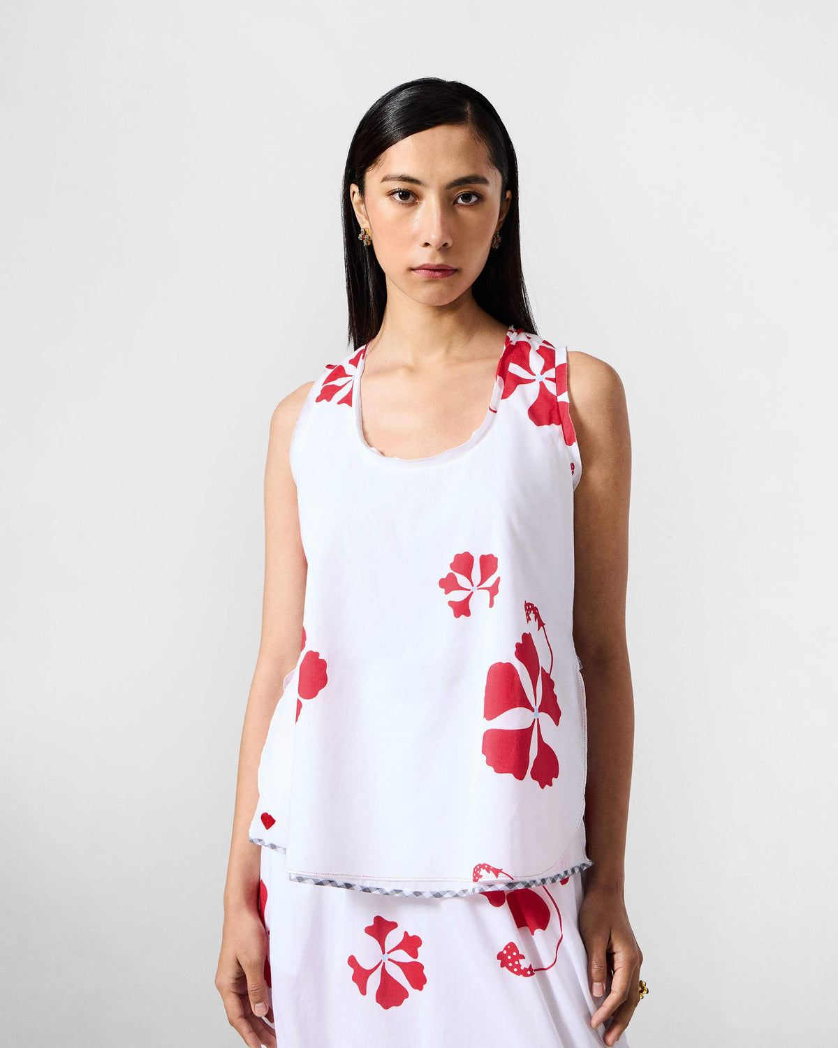 Person wearing the Kiva top in white with a red floral print and round neckline.