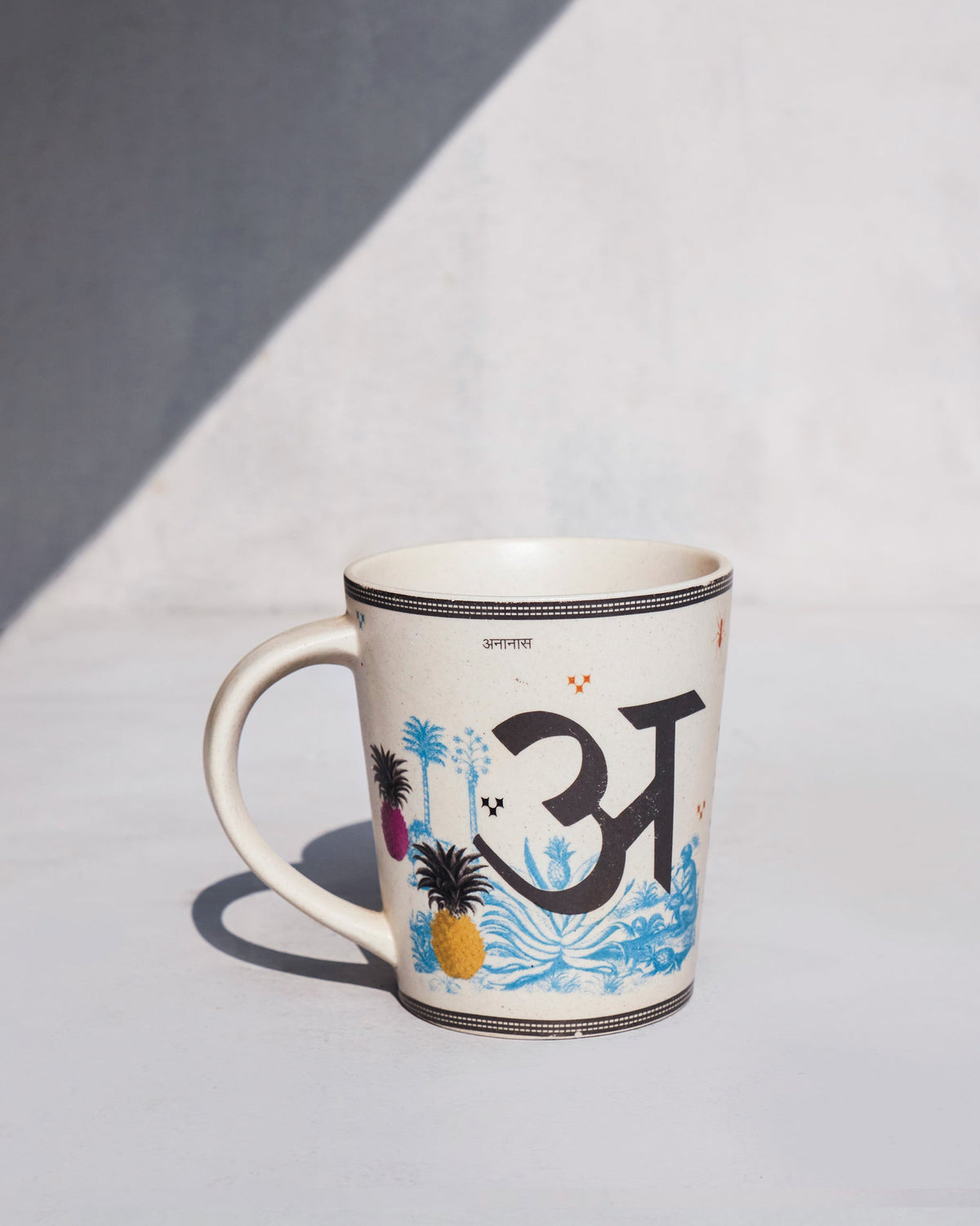 Cream ananas mug with a letter A and pineapple motif.
