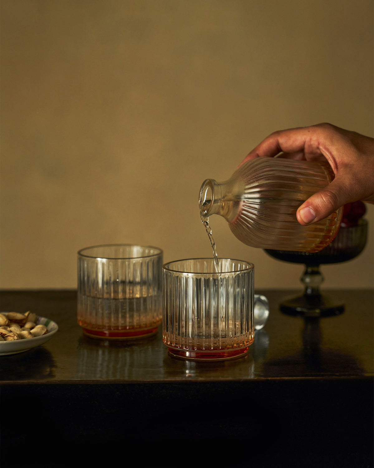 Tarang Bar Gift Set decanter being poured into a ribbed glass.