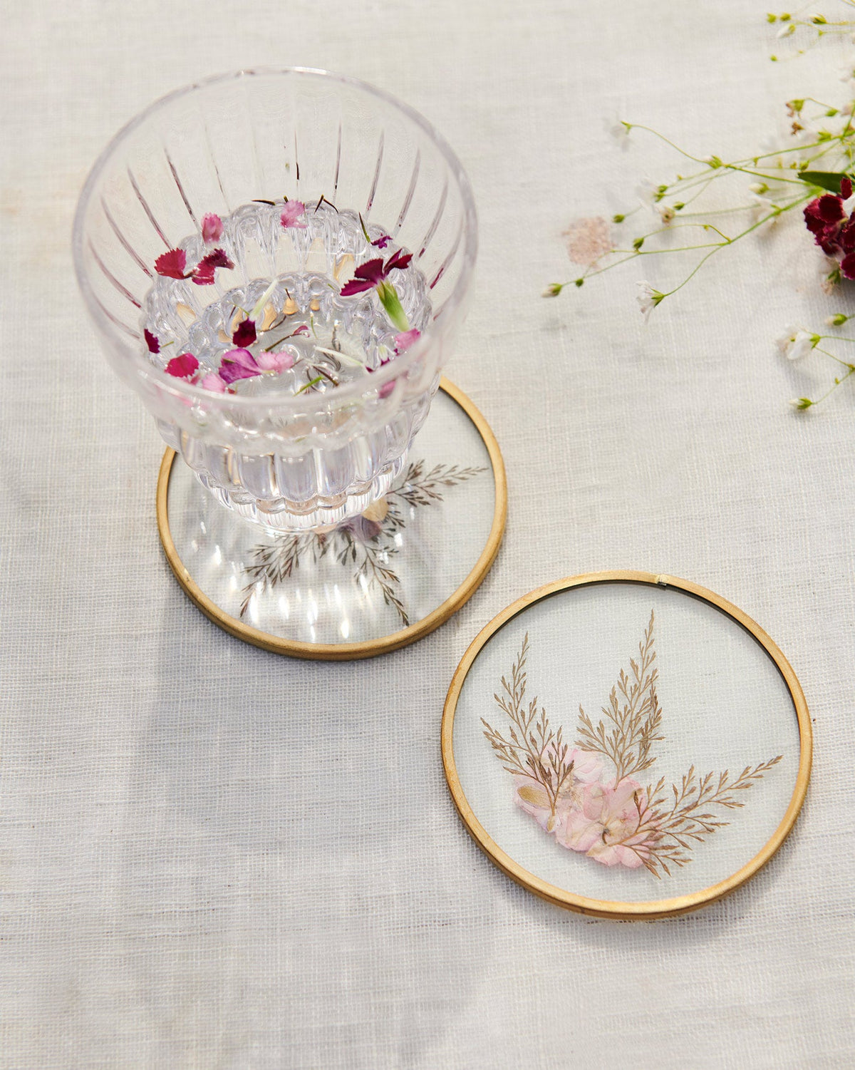 Palm Grove pressed-flower coasters with a fluted glass of water.