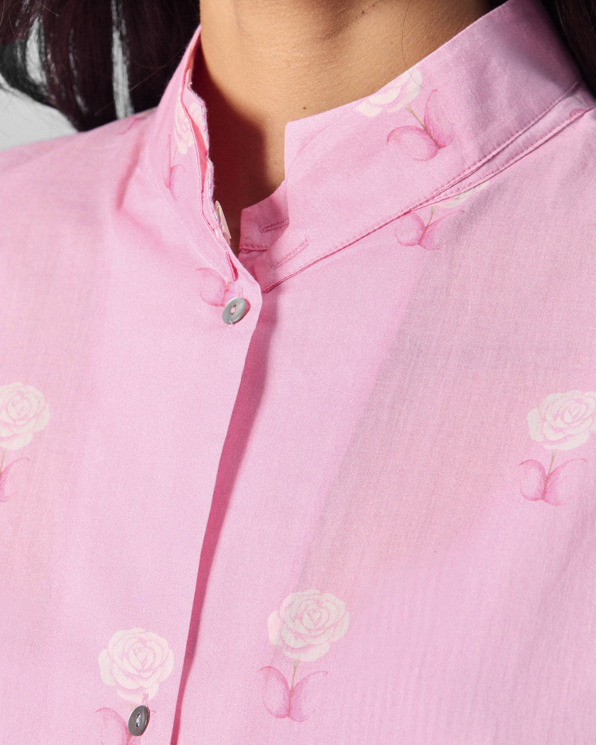 Close-up of a pink floral tunic mandarin collar with rose print.