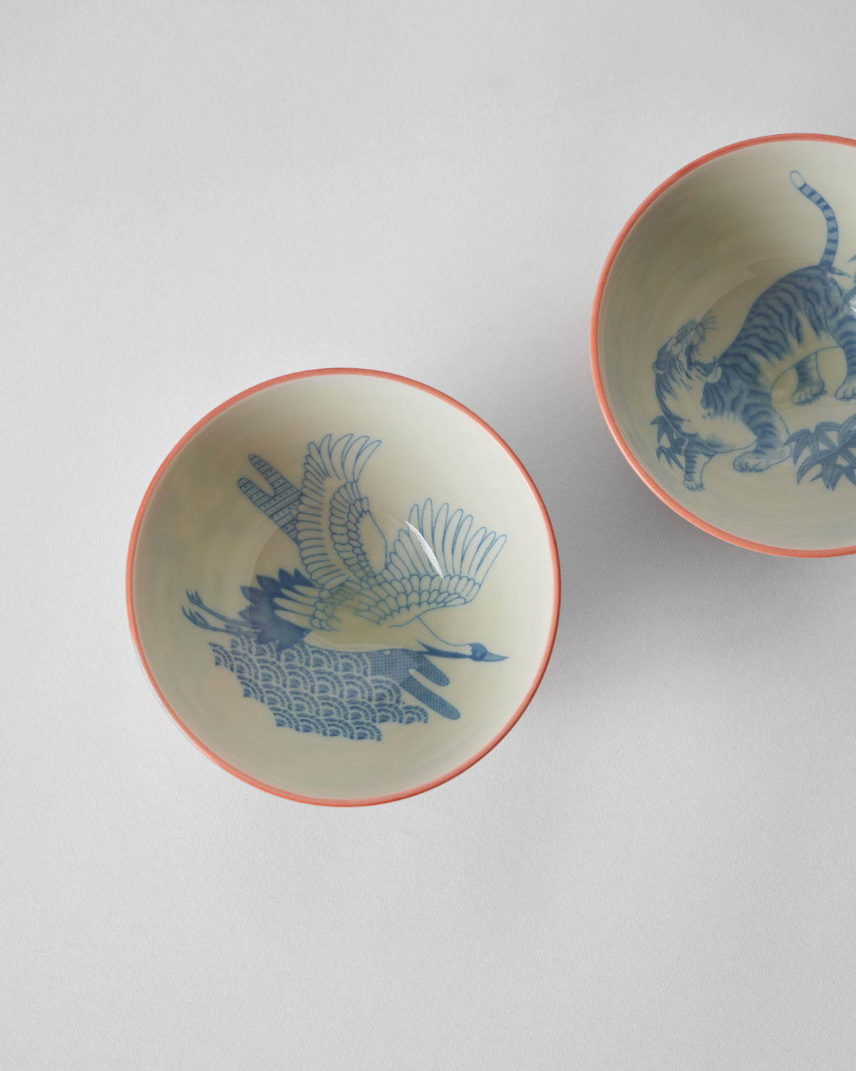 Cream interiors of Crane and Tiger bowls with blue crane and tiger motifs.