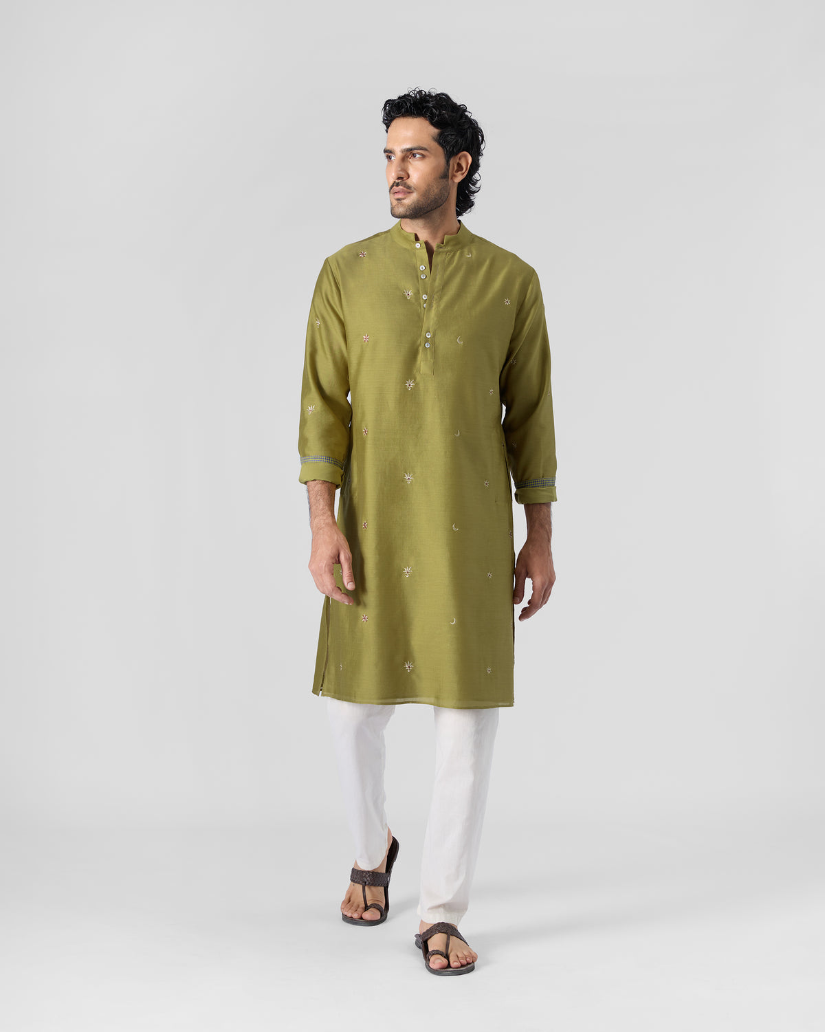 Person in an olive Rey kurta with small embroidered motifs, shown full length.