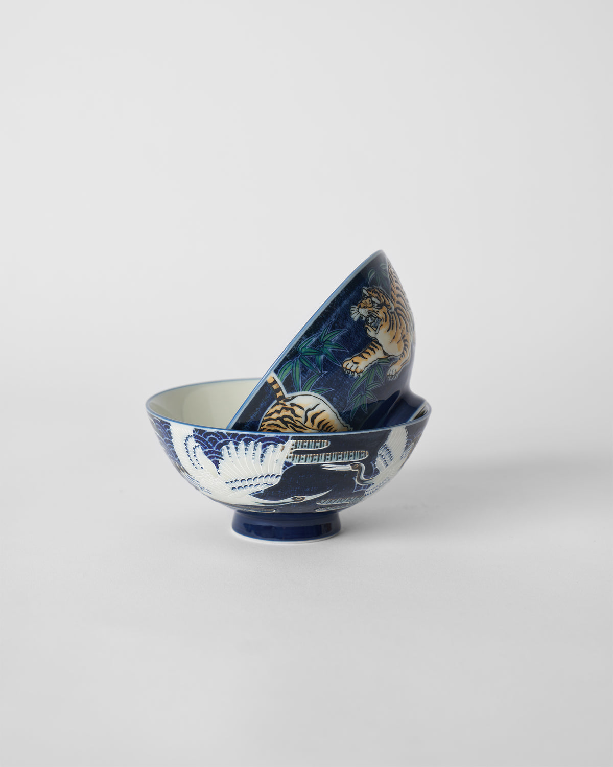 Nested blue Crane and Tiger Bowls showing crane and tiger exteriors.