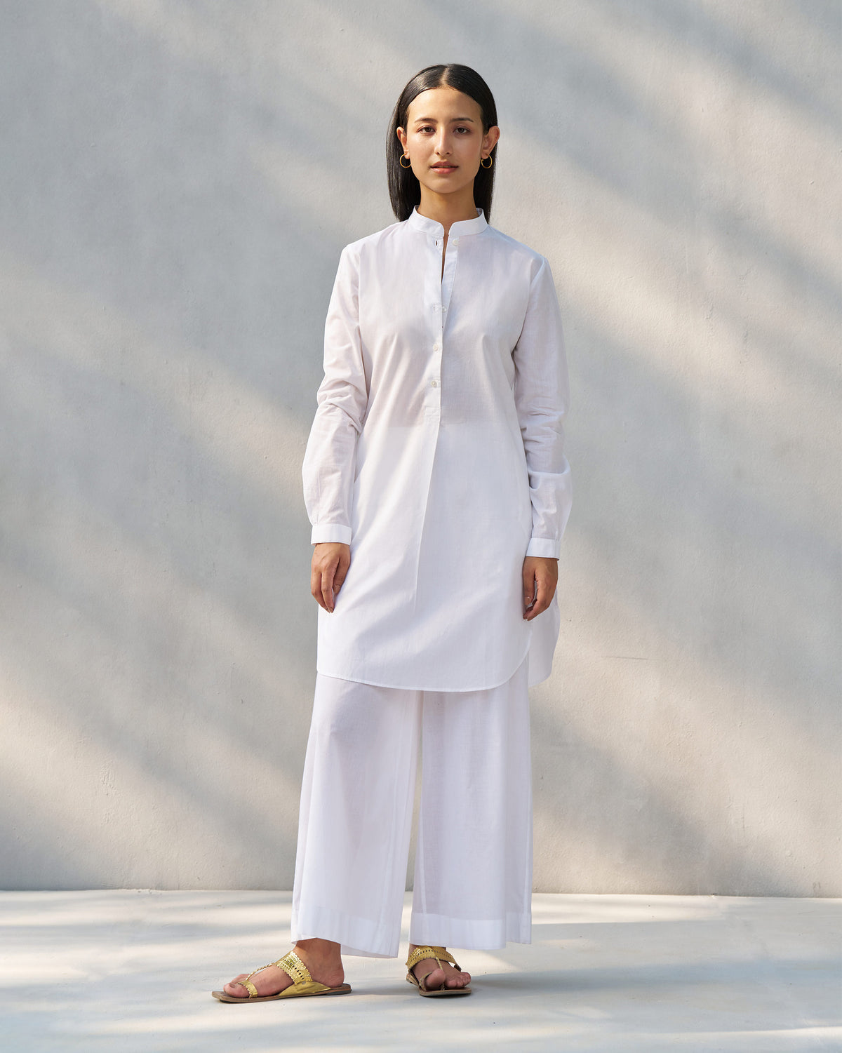 Person wearing a white Moon set tunic and matching wide pants.