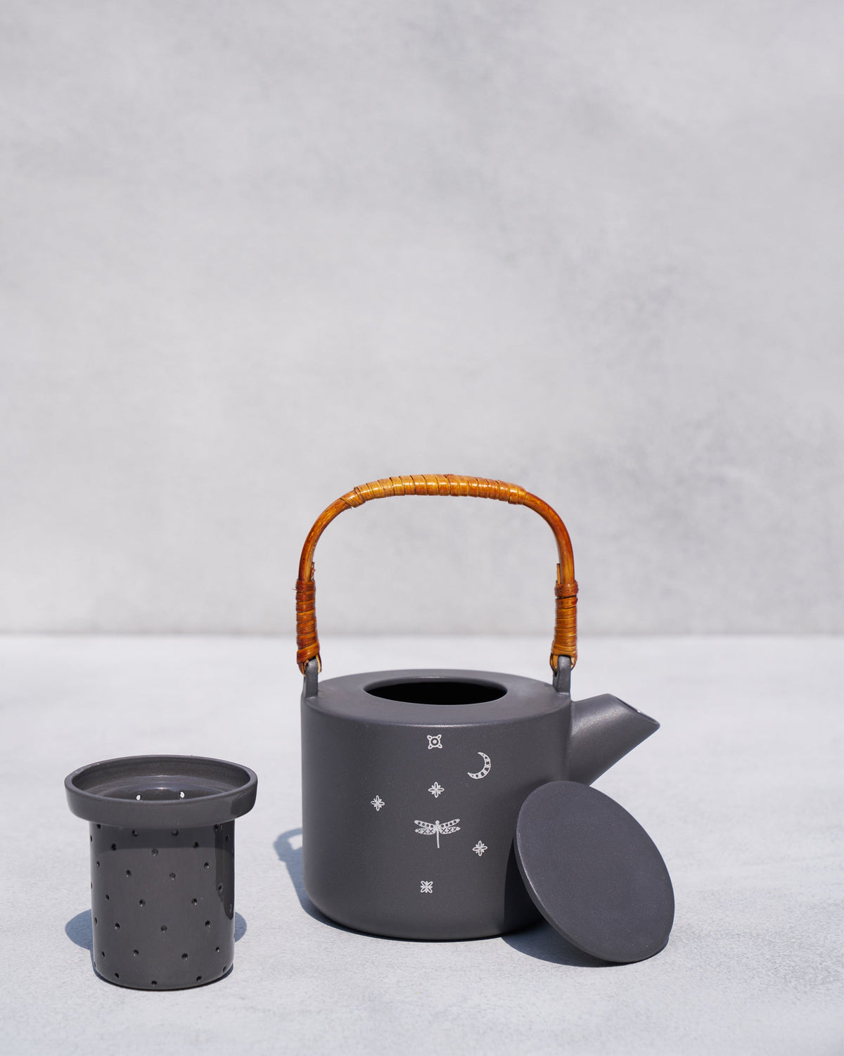 Taramandal teapot with its ceramic infuser and lid removed beside it.