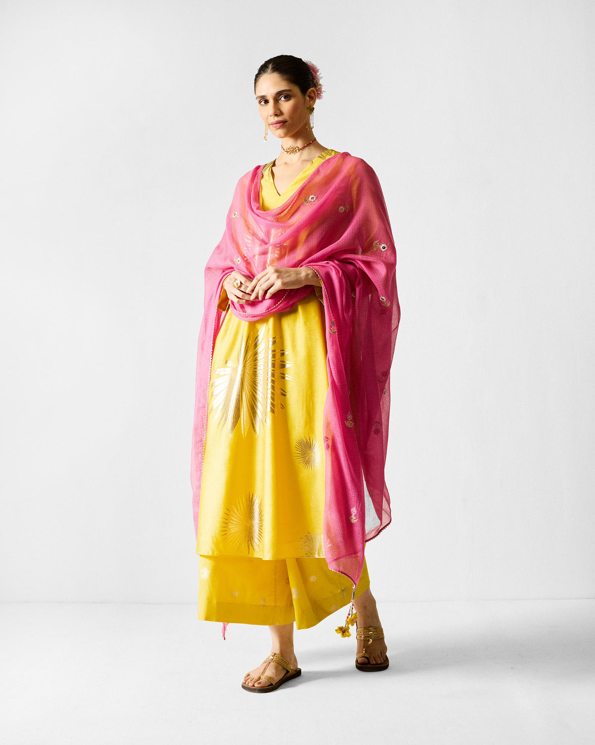 Person wearing a chartreuse gold-printed V-neck kurta with a pink dupatta.
