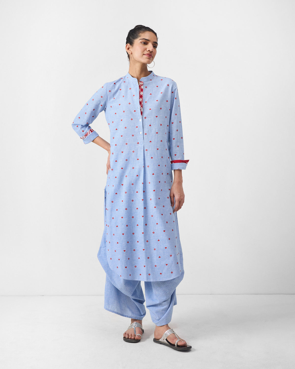 Person wearing a light blue Sakura set with red print and contrast cuffs.