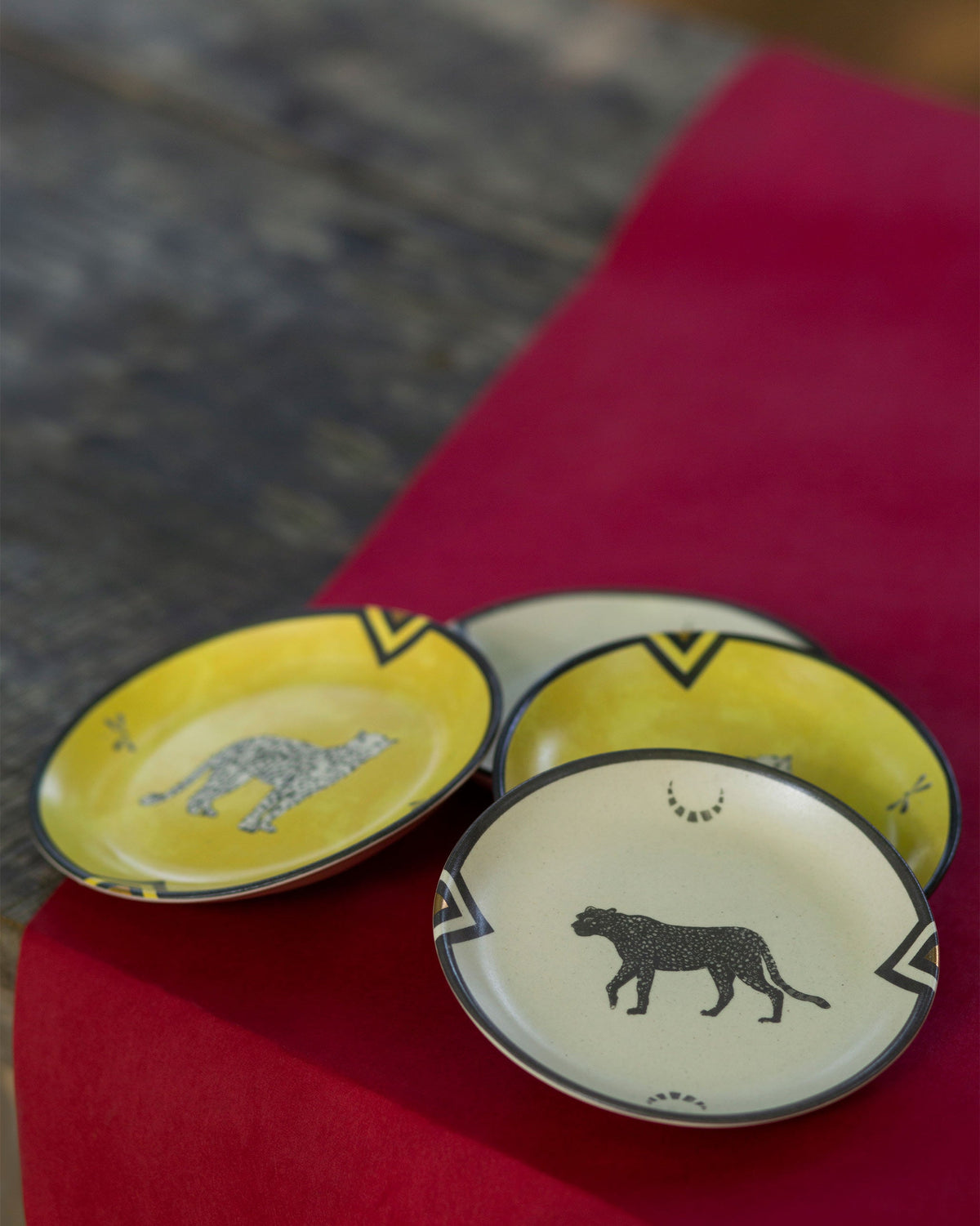 Cluster of Chand tea plates with yellow and cream leopard designs.