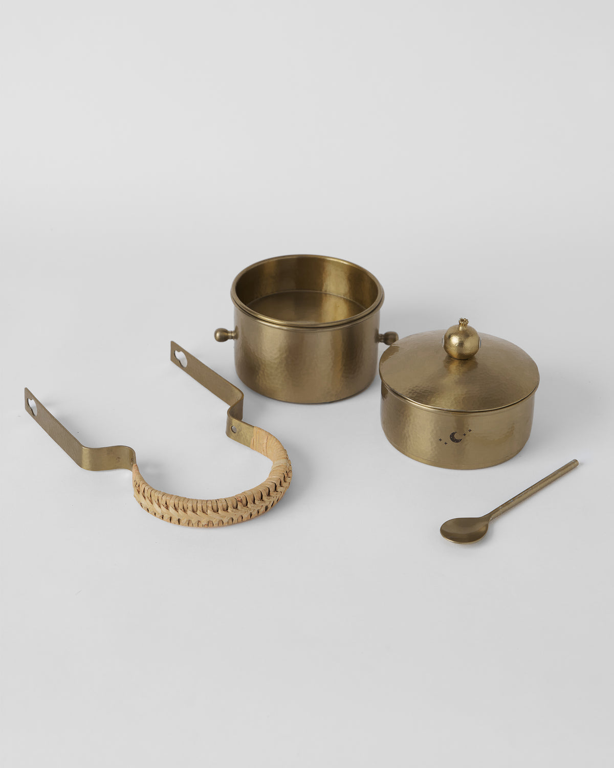 Gold Chand tiffin box components laid out with a rattan handle.