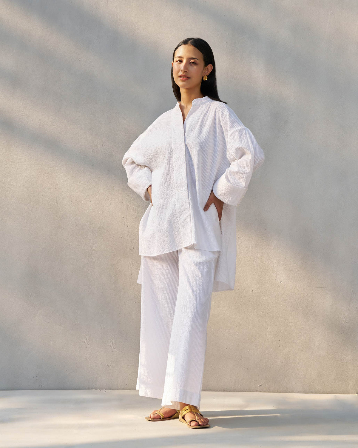 Person wearing a white Cirrus seersucker shirt with matching wide-leg trousers.