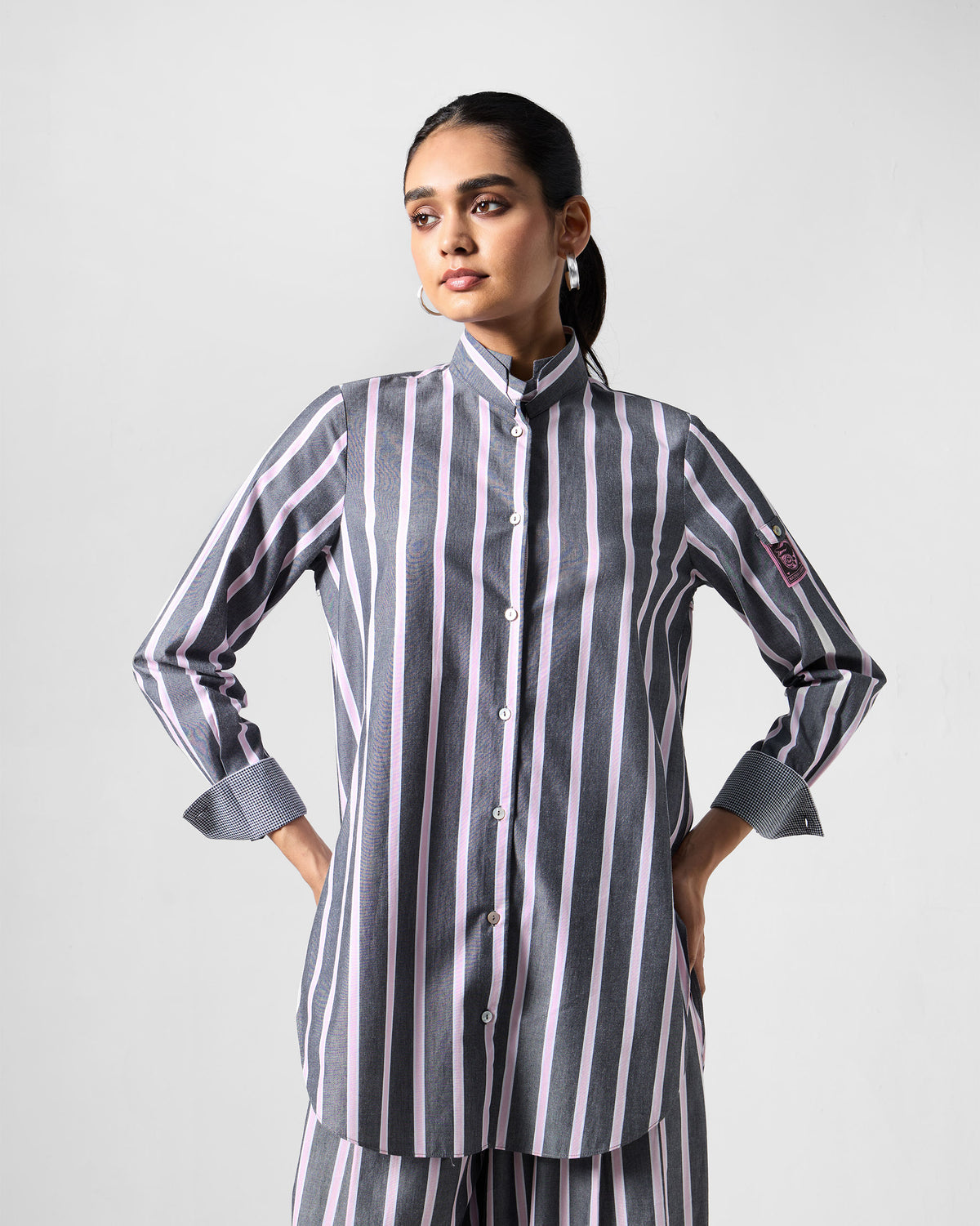 Person wearing a charcoal and pink striped Trench shirt set.