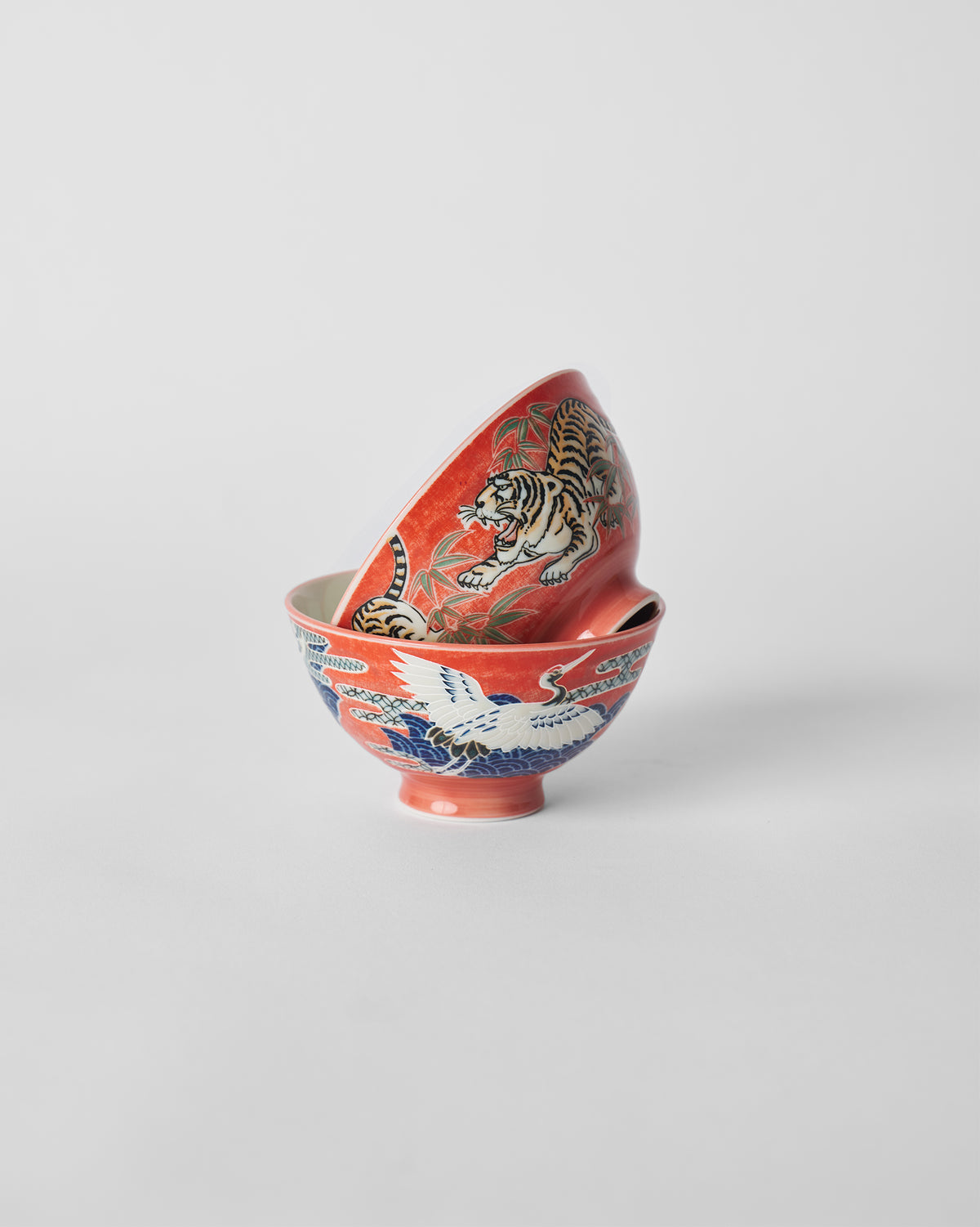 Nested red Crane and Tiger Bowls showing crane and tiger exteriors.