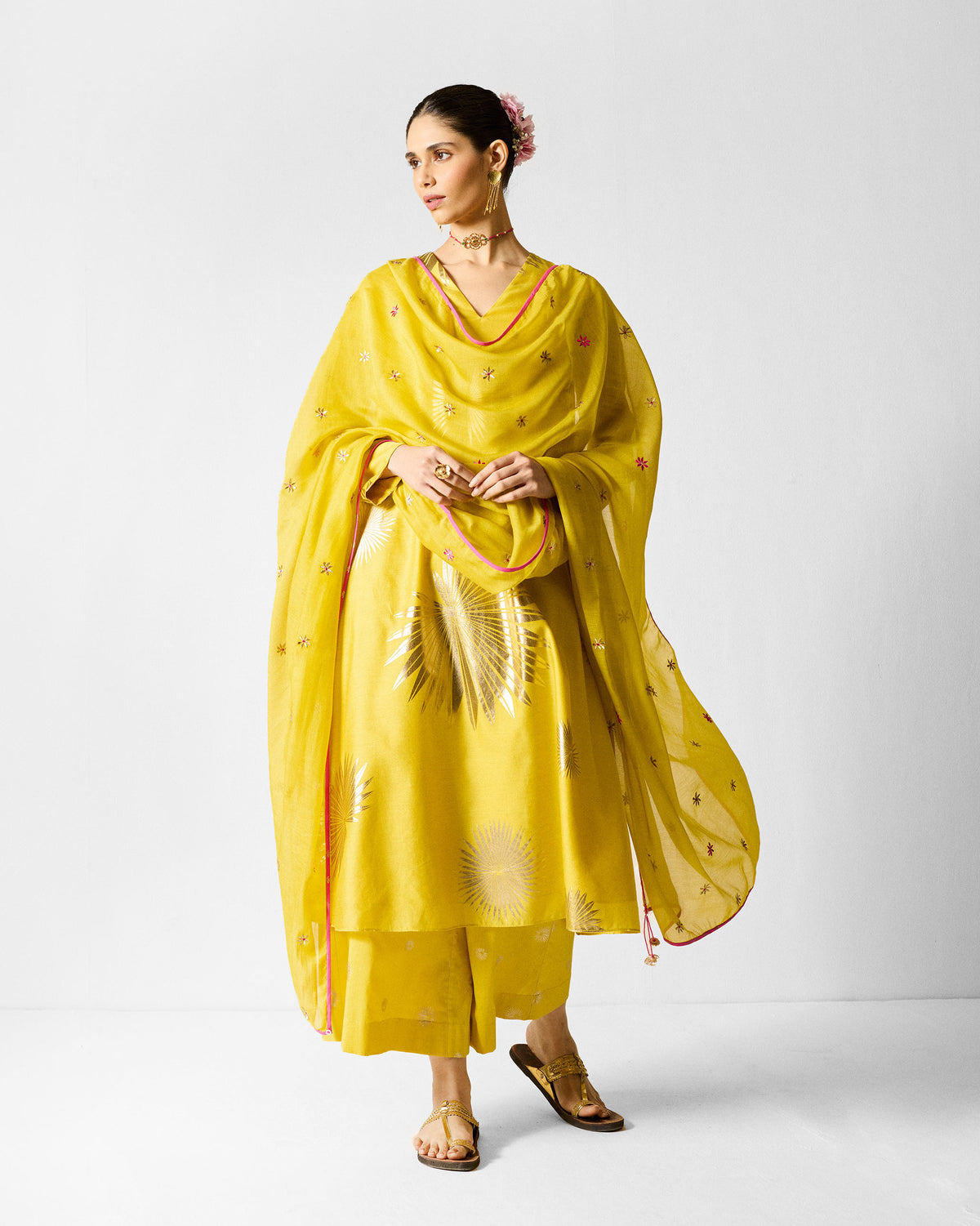 Person wearing a chartreuse gold-printed V-neck flared kurta with a sheer dupatta.