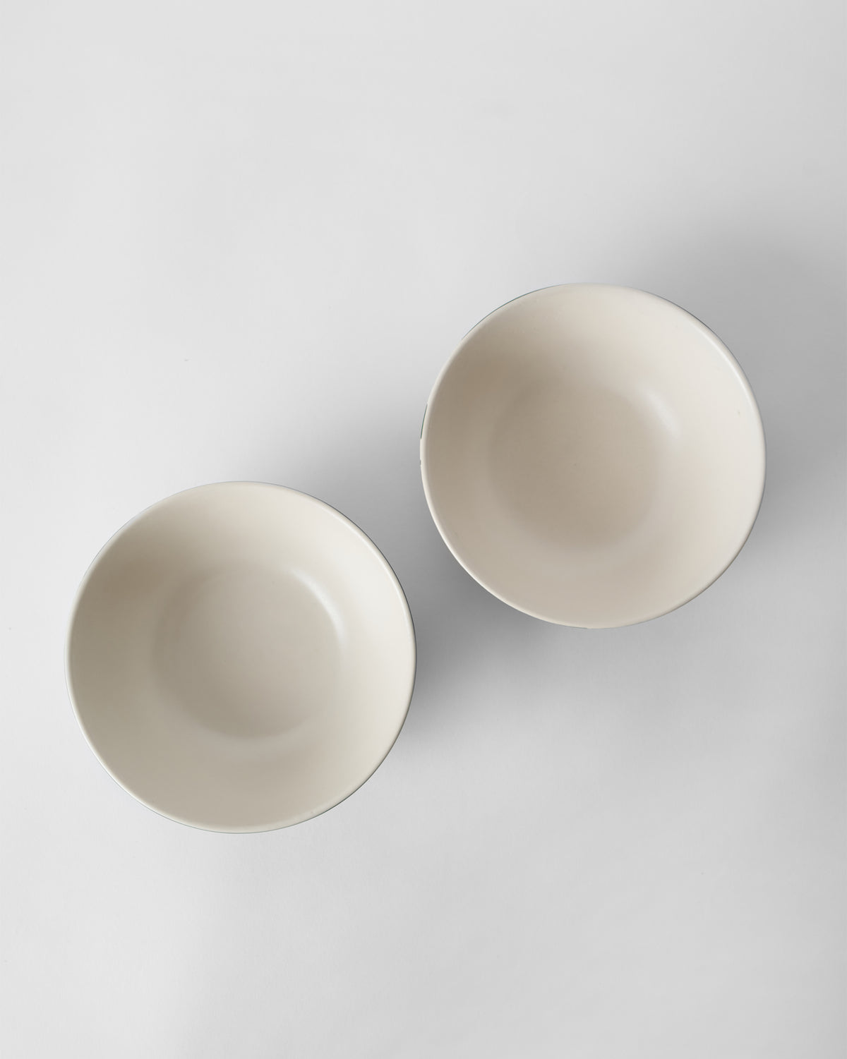 Top-down view of two cream interiors of Reesha vegetable bowls.